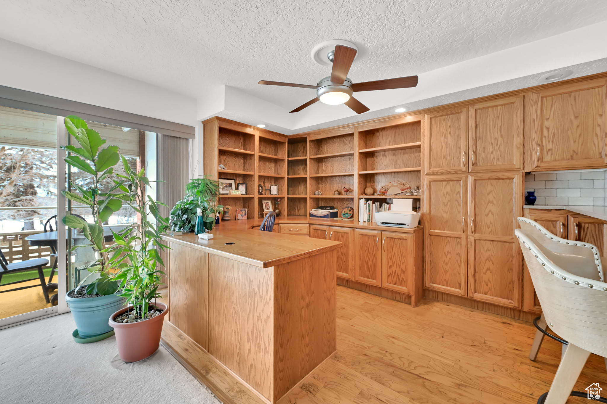 Office with ceiling fan, light wood finished floors, and a textured ceiling