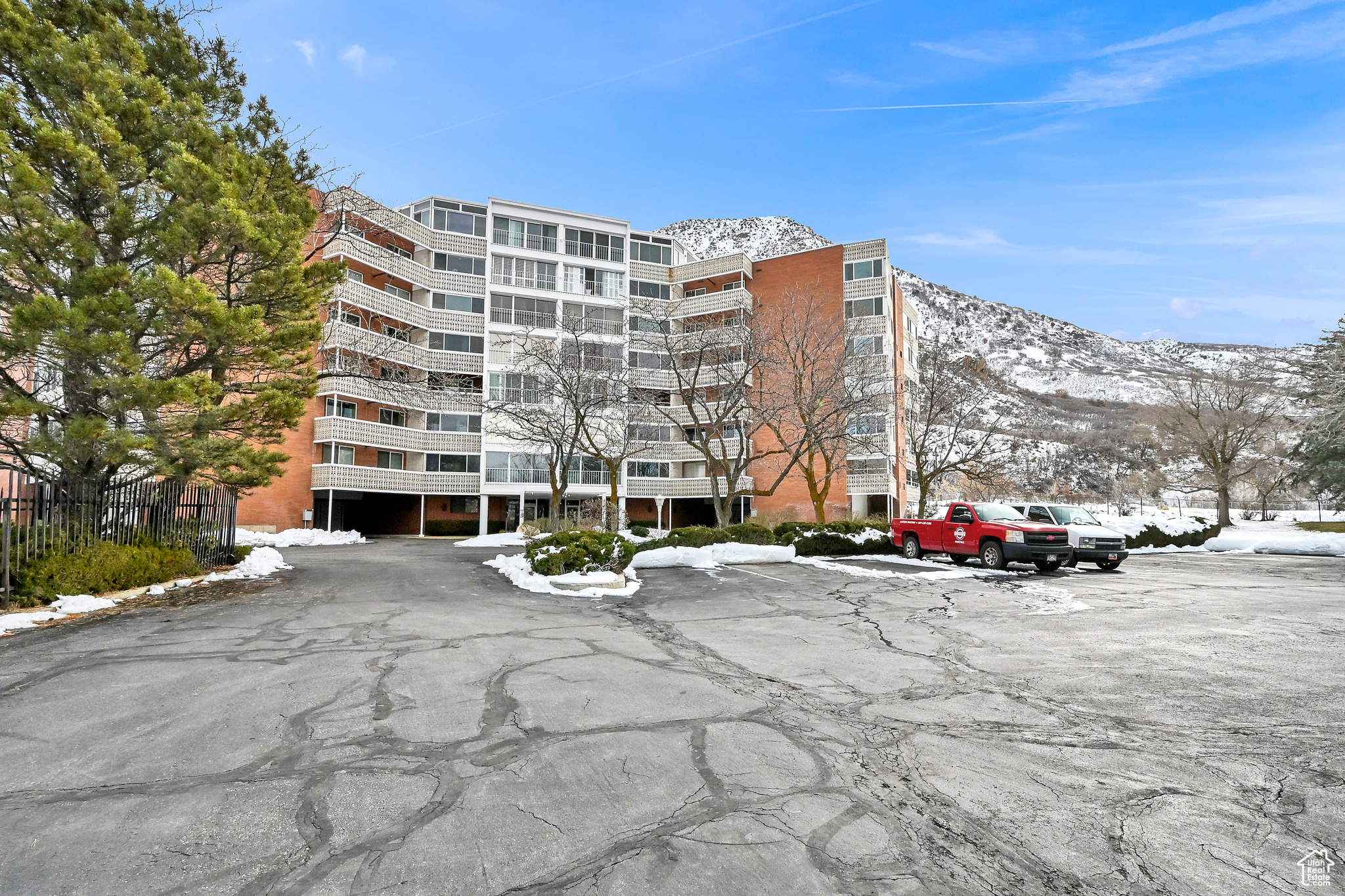 Snow covered building with uncovered parking and a mountain view