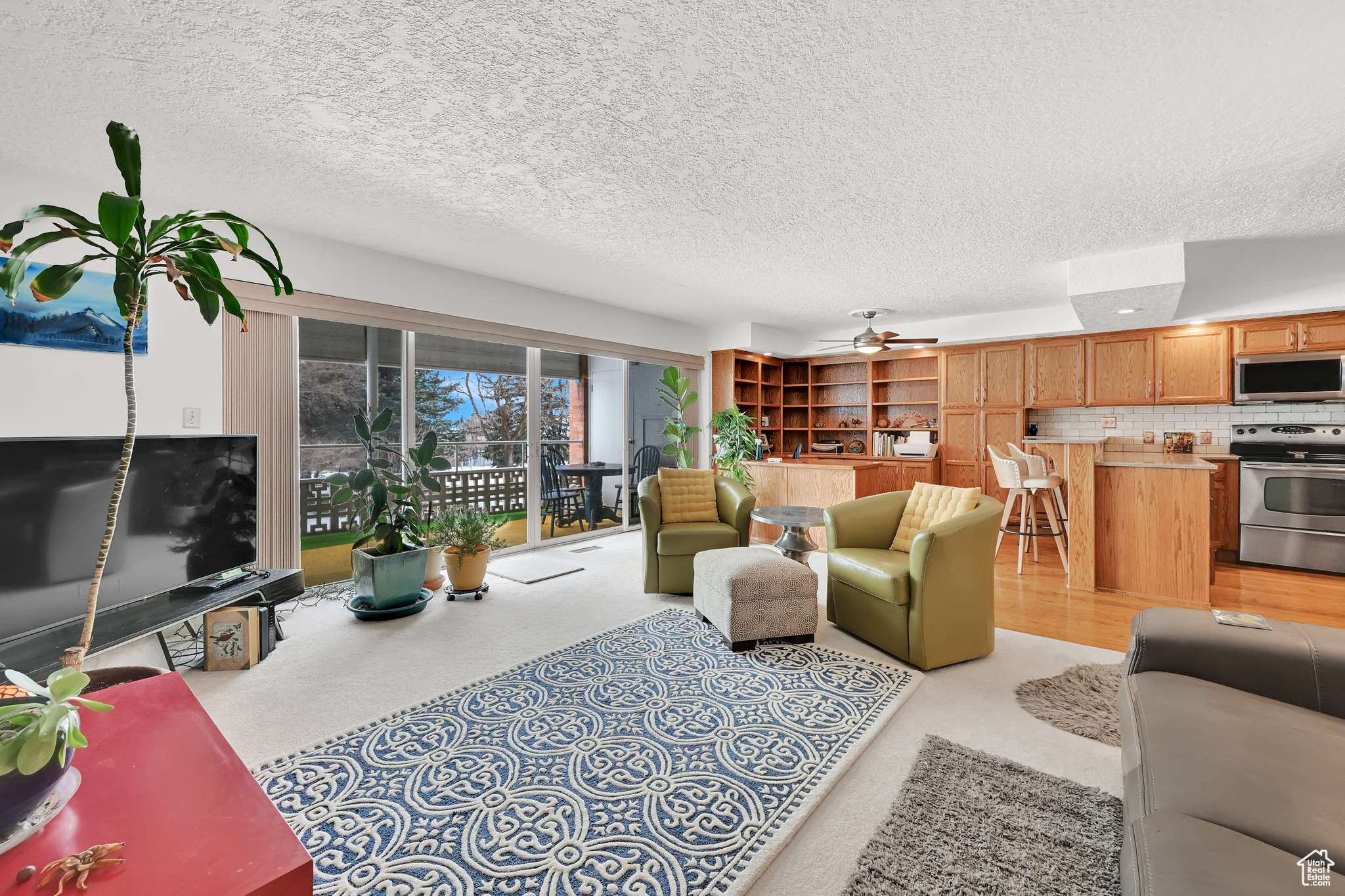 Living room with a textured ceiling and a ceiling fan