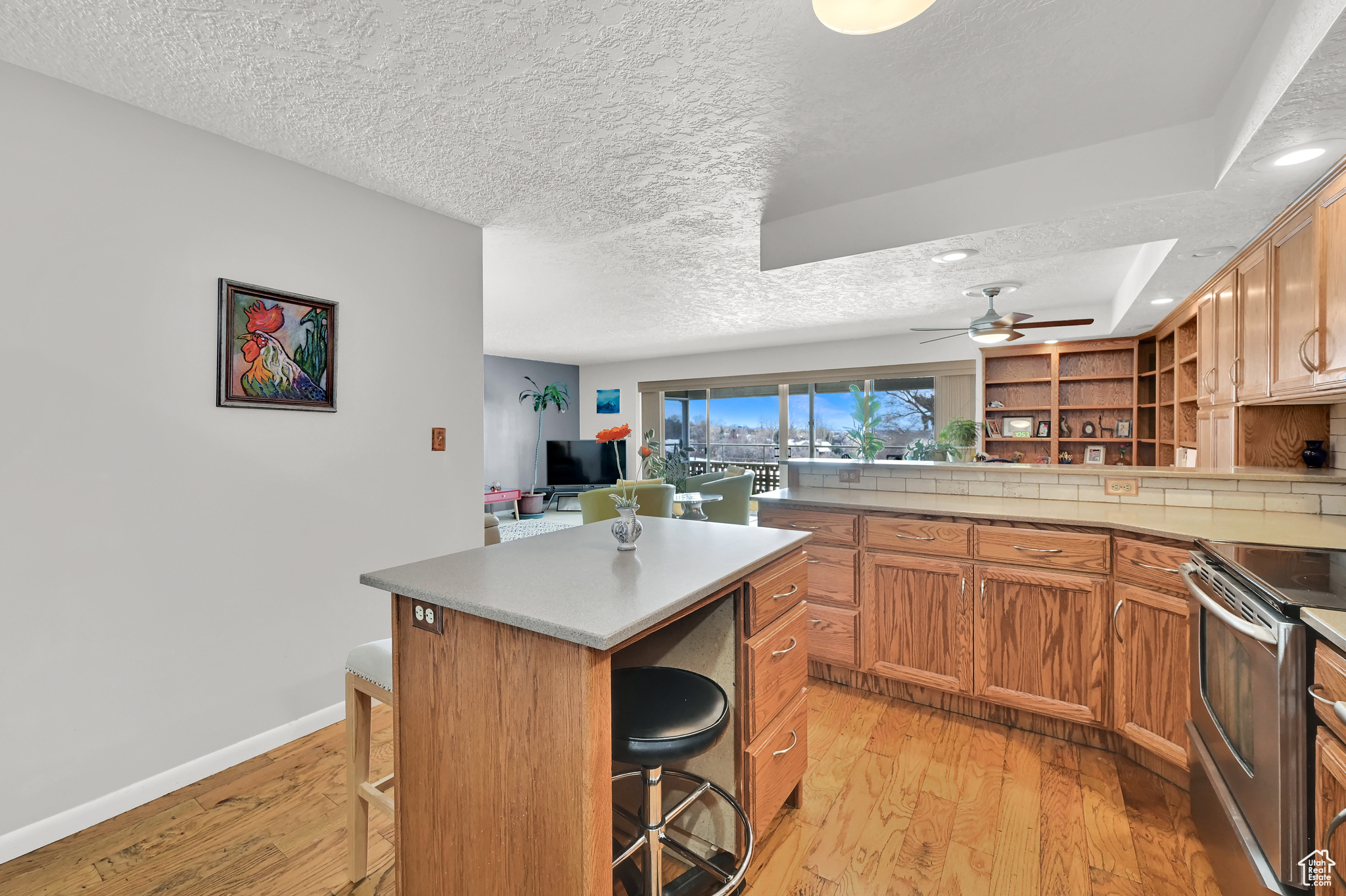 Kitchen featuring light wood-type flooring, a breakfast bar, a center island, and stainless steel electric range oven