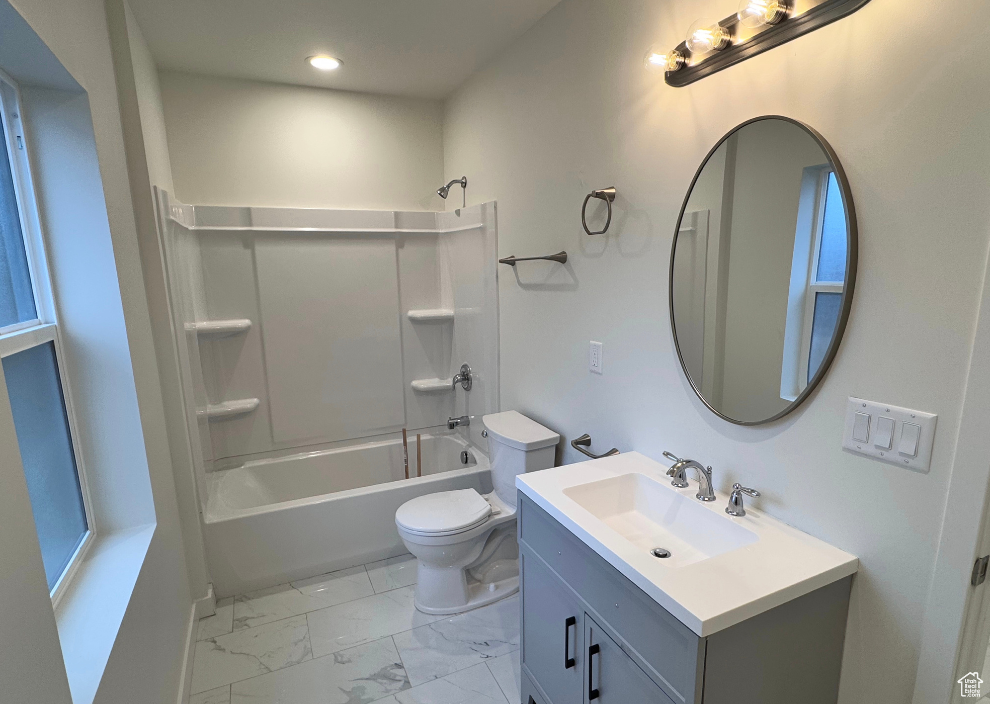 Full bathroom featuring toilet, marble finish floor, bathtub / shower combination, vanity, and recessed lighting