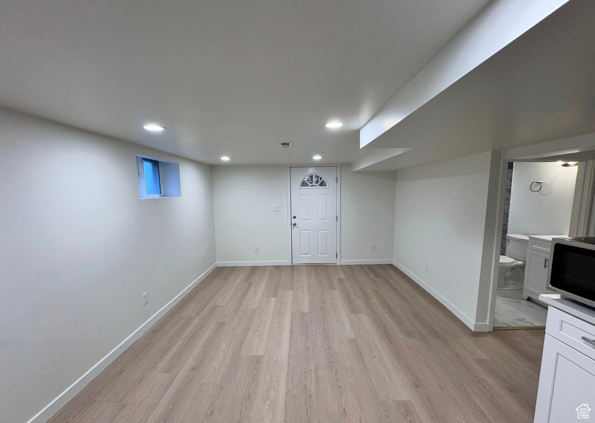 Finished basement with light wood-style floors, baseboards, and recessed lighting