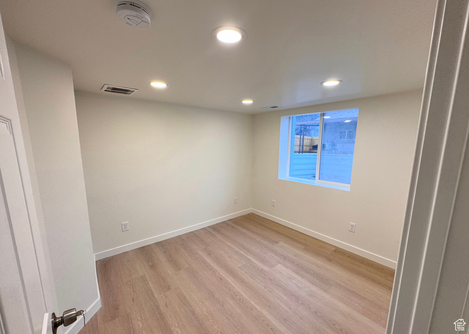 Spare room featuring light wood-style flooring, recessed lighting, visible vents, and baseboards