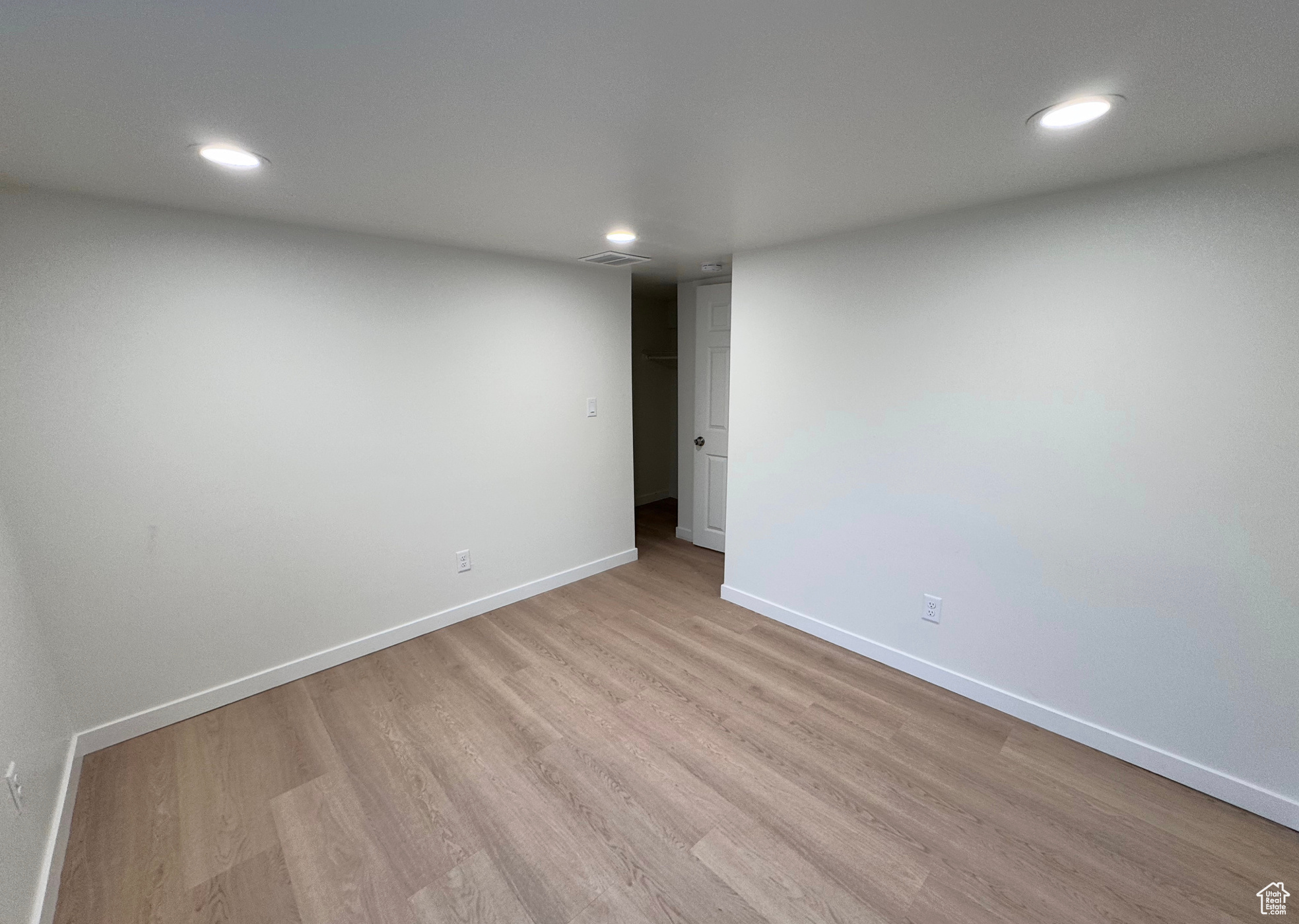 Unfurnished room featuring light wood-type flooring, visible vents, baseboards, and recessed lighting