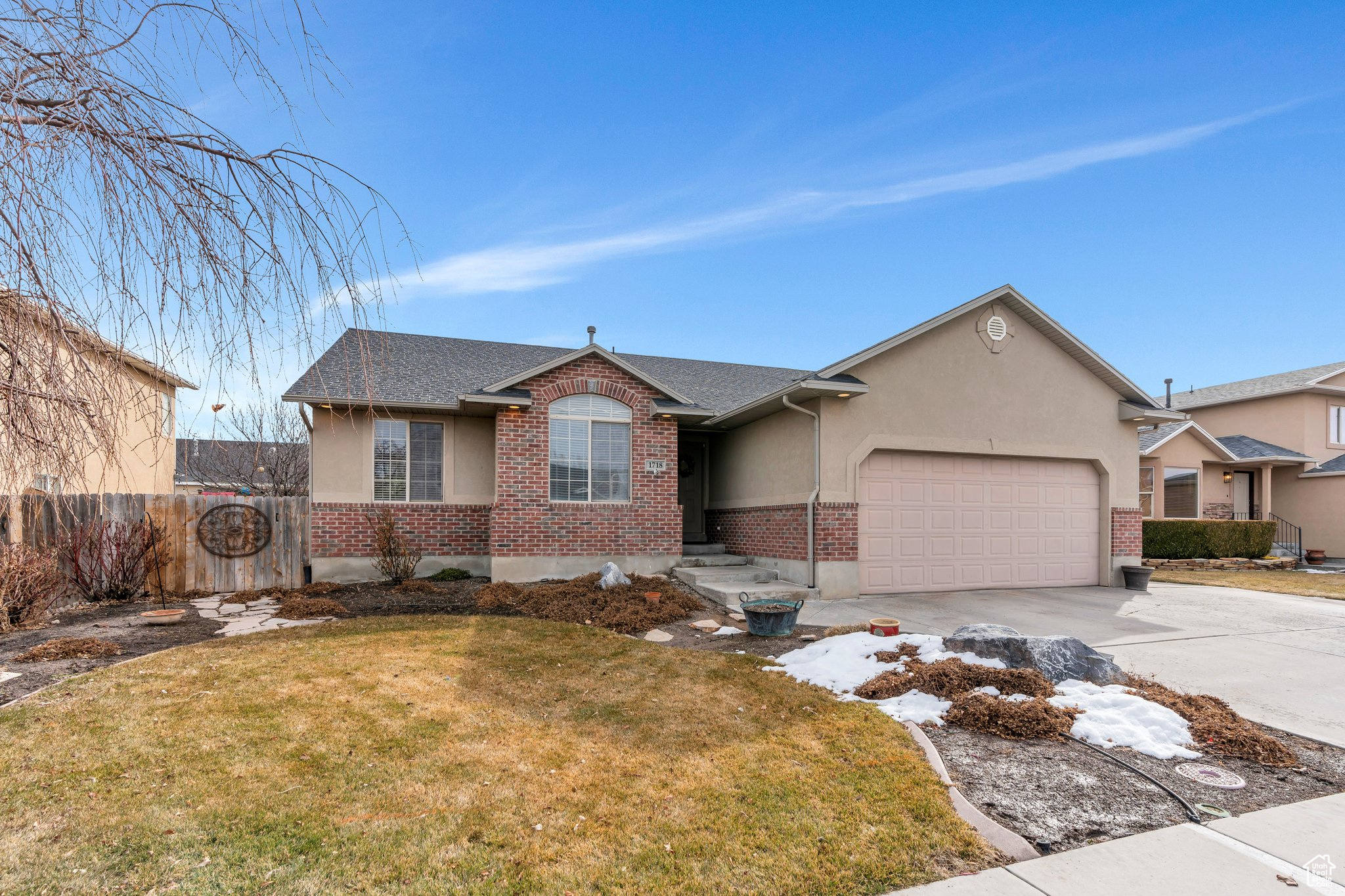 Single story home with a garage, fence, a front lawn, and brick siding