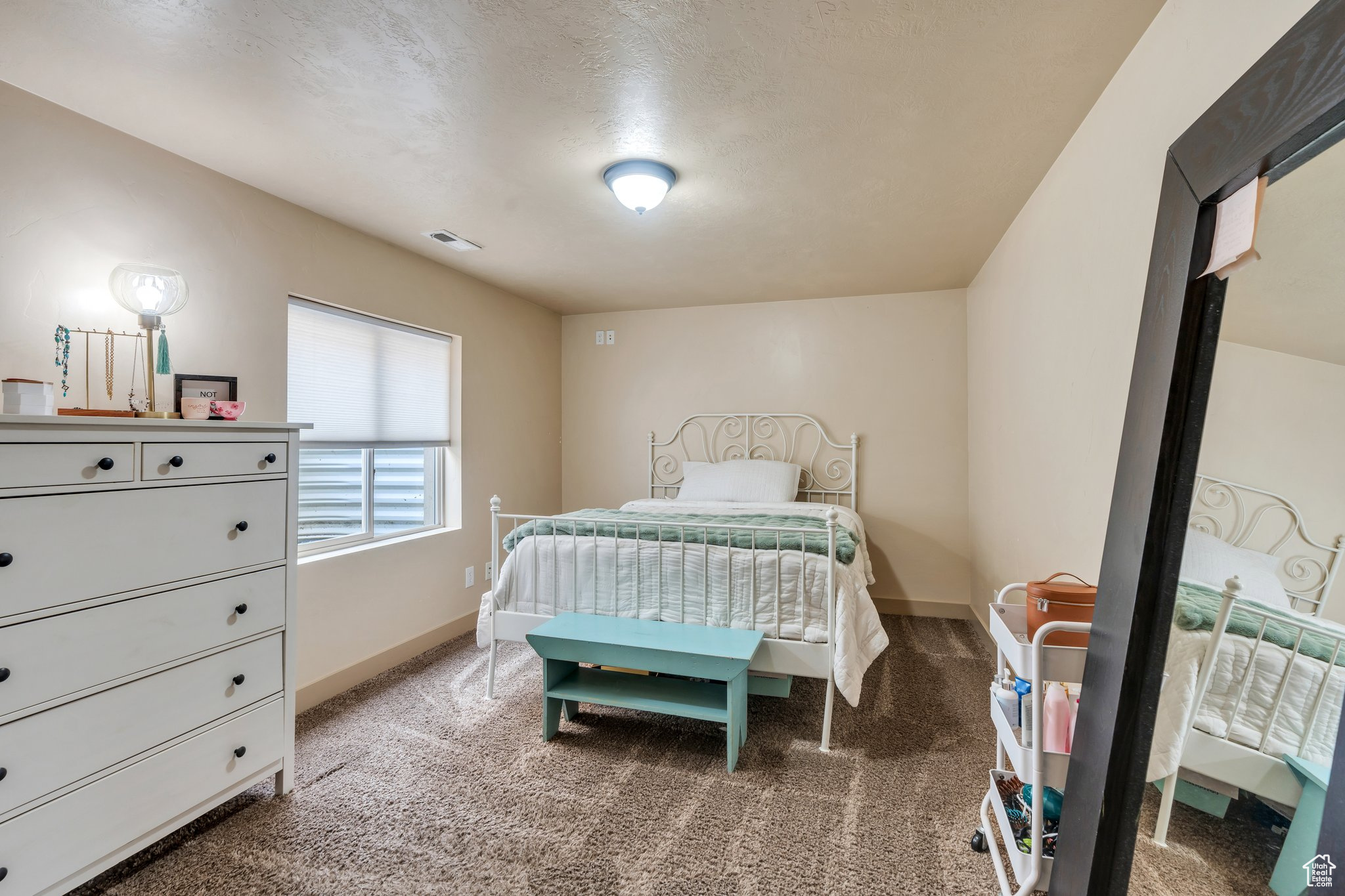 Bedroom featuring a textured ceiling, dark carpet, visible vents, and baseboards