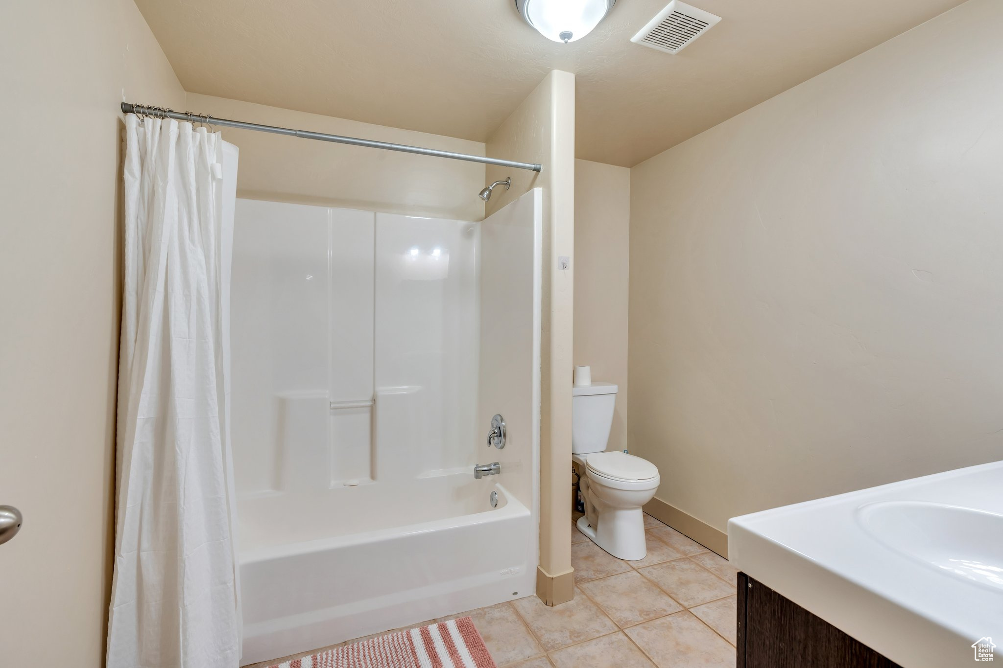 Full bath with visible vents, toilet, shower / tub combo, vanity, and tile patterned floors