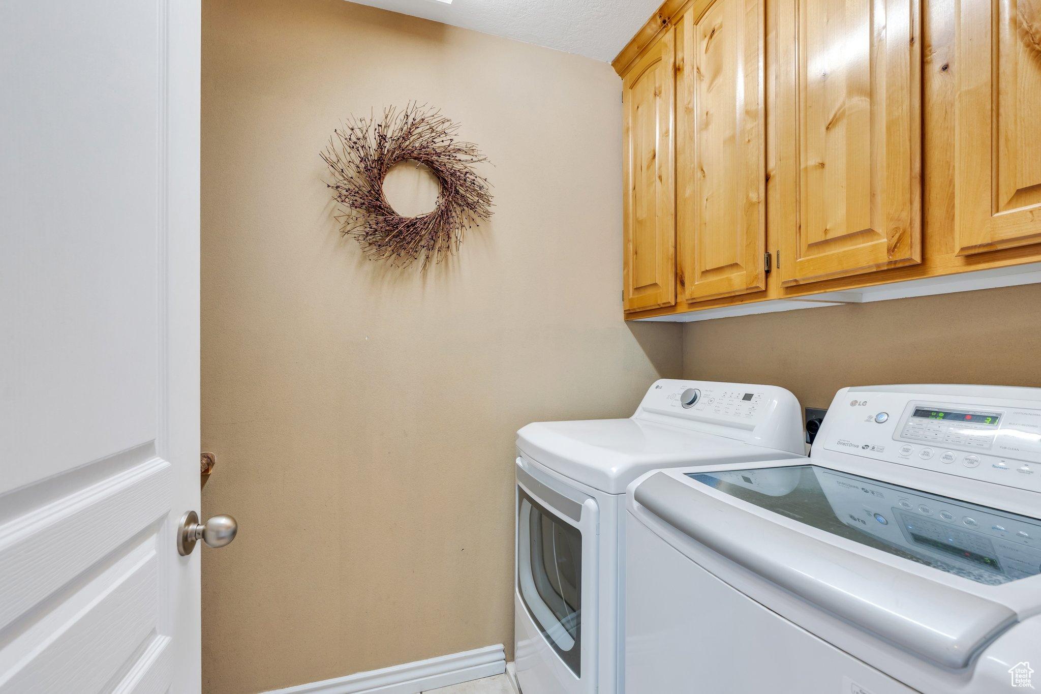 Laundry area with baseboards, cabinet space, and washing machine and clothes dryer