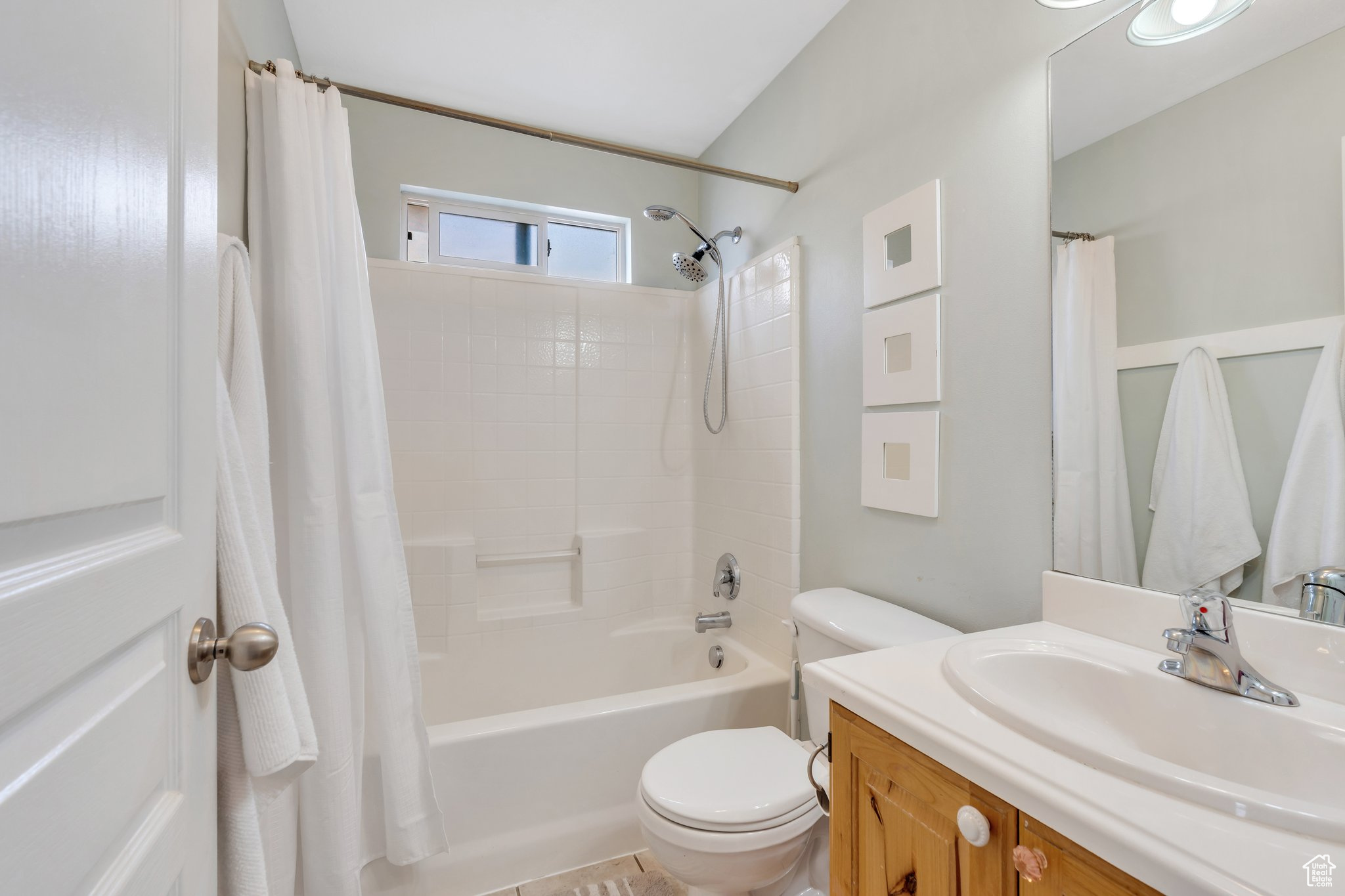 Bathroom with shower / tub combo, vanity, and toilet