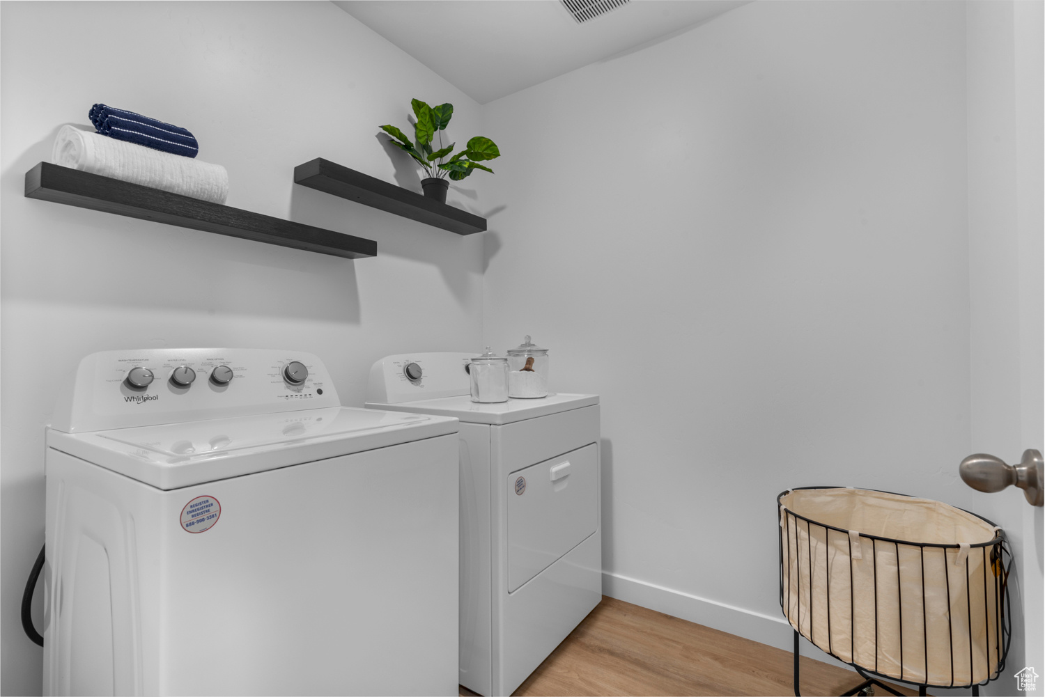 Laundry room with laundry area, baseboards, radiator, light wood-style flooring, and independent washer and dryer