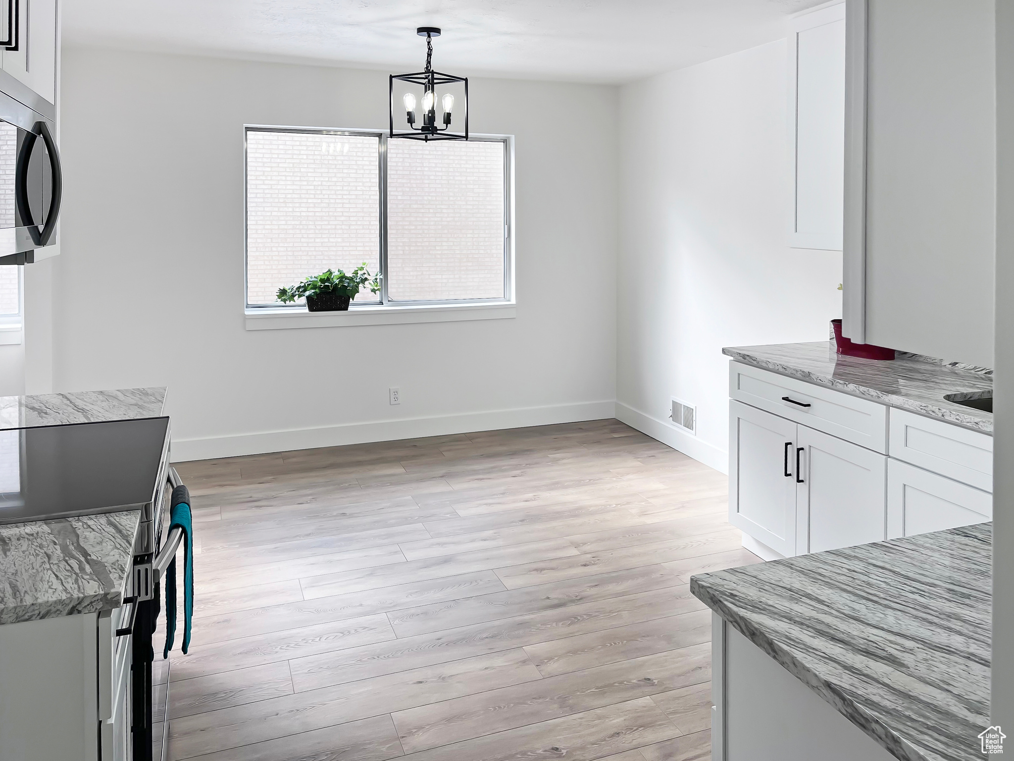 Dining space with light wood-style floors conveniently adjacent to the kitchen