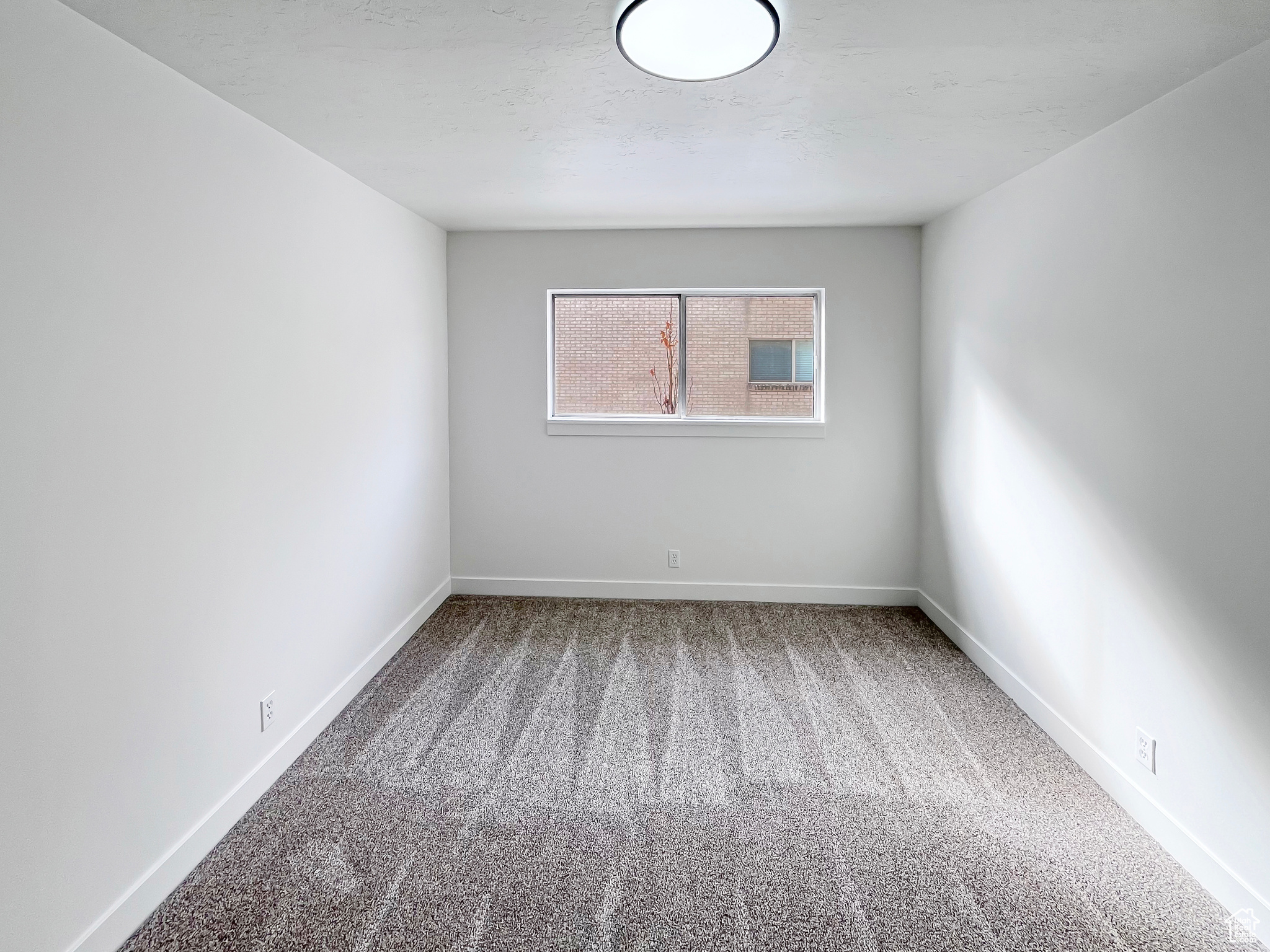 Virtually staged second bedroom featuring a large room and soft, new carpet