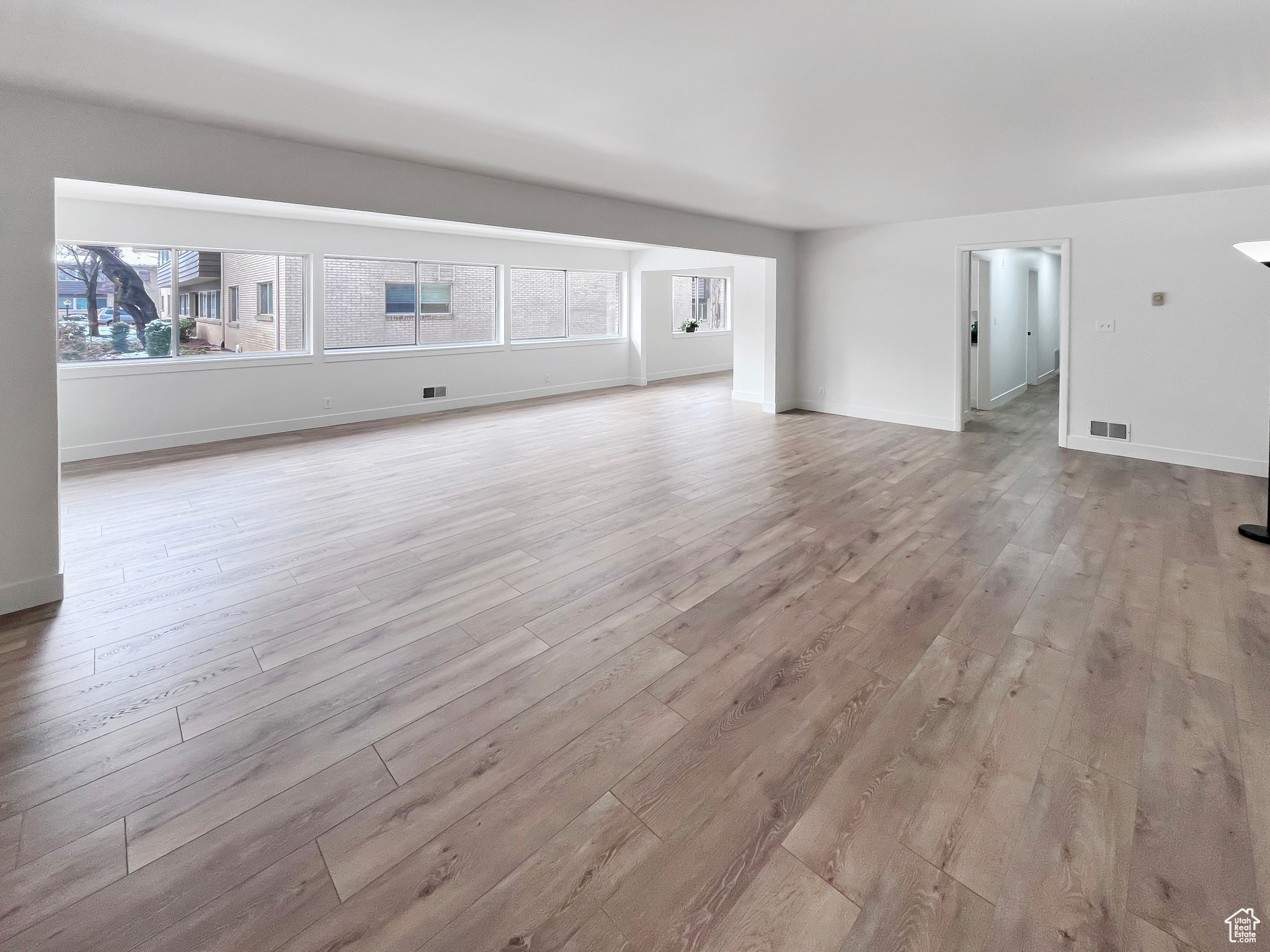 Living area with a healthy amount of sunlight, light wood-style flooring and tasteful interior colors