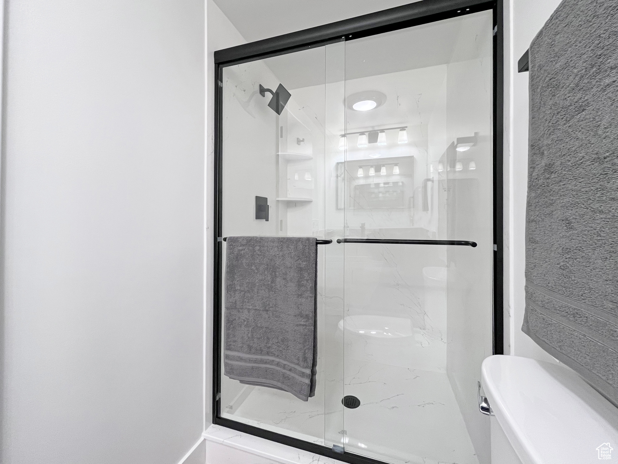Beautifully updated full bath featuring a large shower stall and toilet