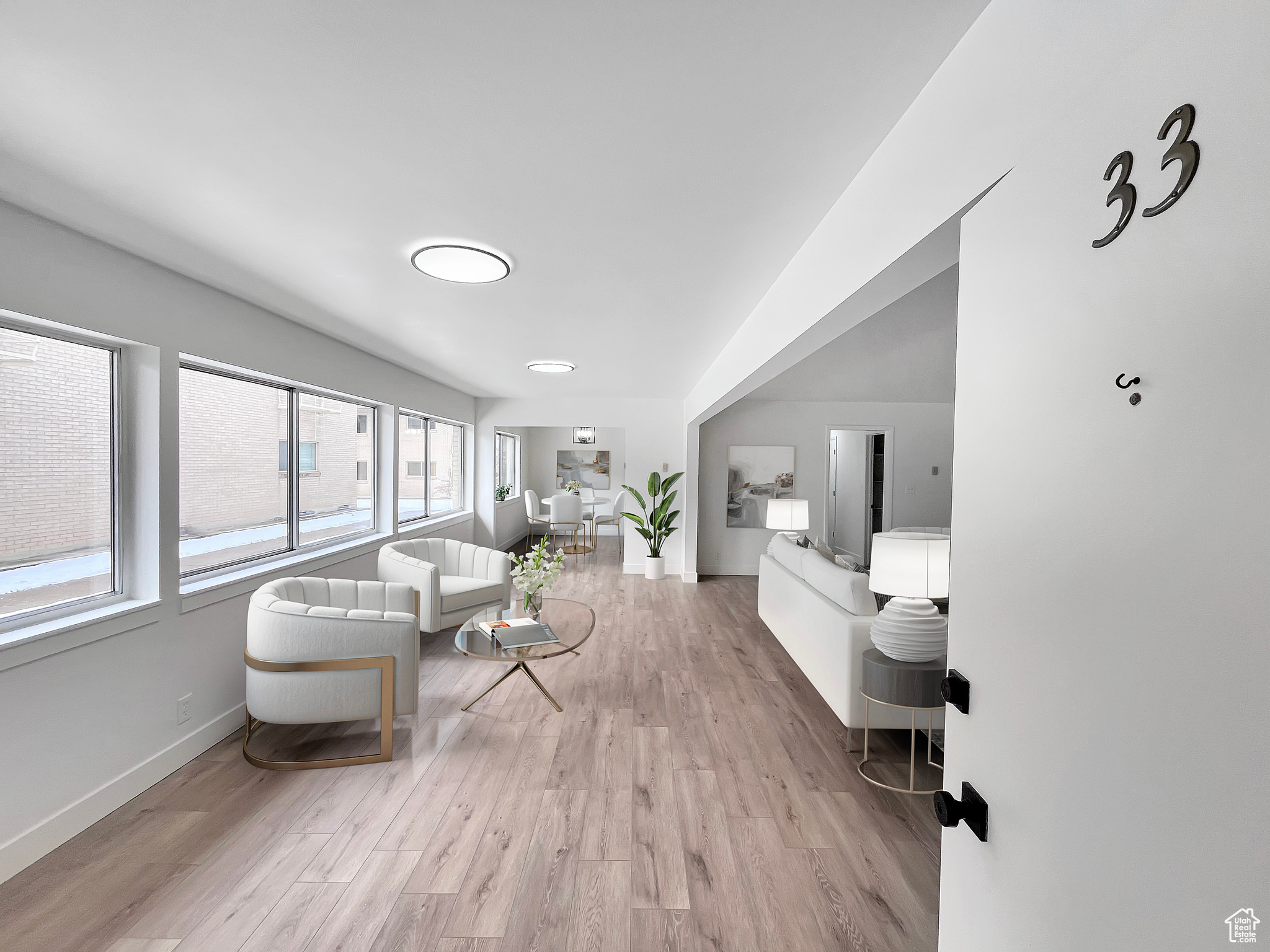 Virtually staged living area featuring light wood-style floors and ample lighting