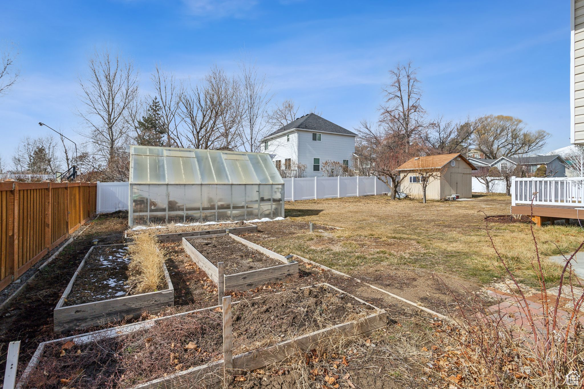 View of yard featuring an outbuilding, an exterior structure, a fenced backyard, and a shed