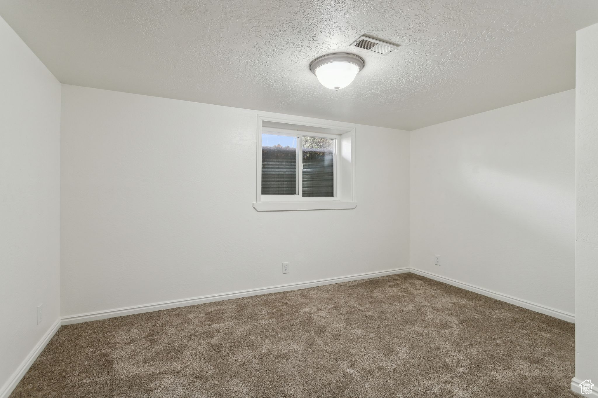 Empty room featuring baseboards, visible vents, and carpet flooring