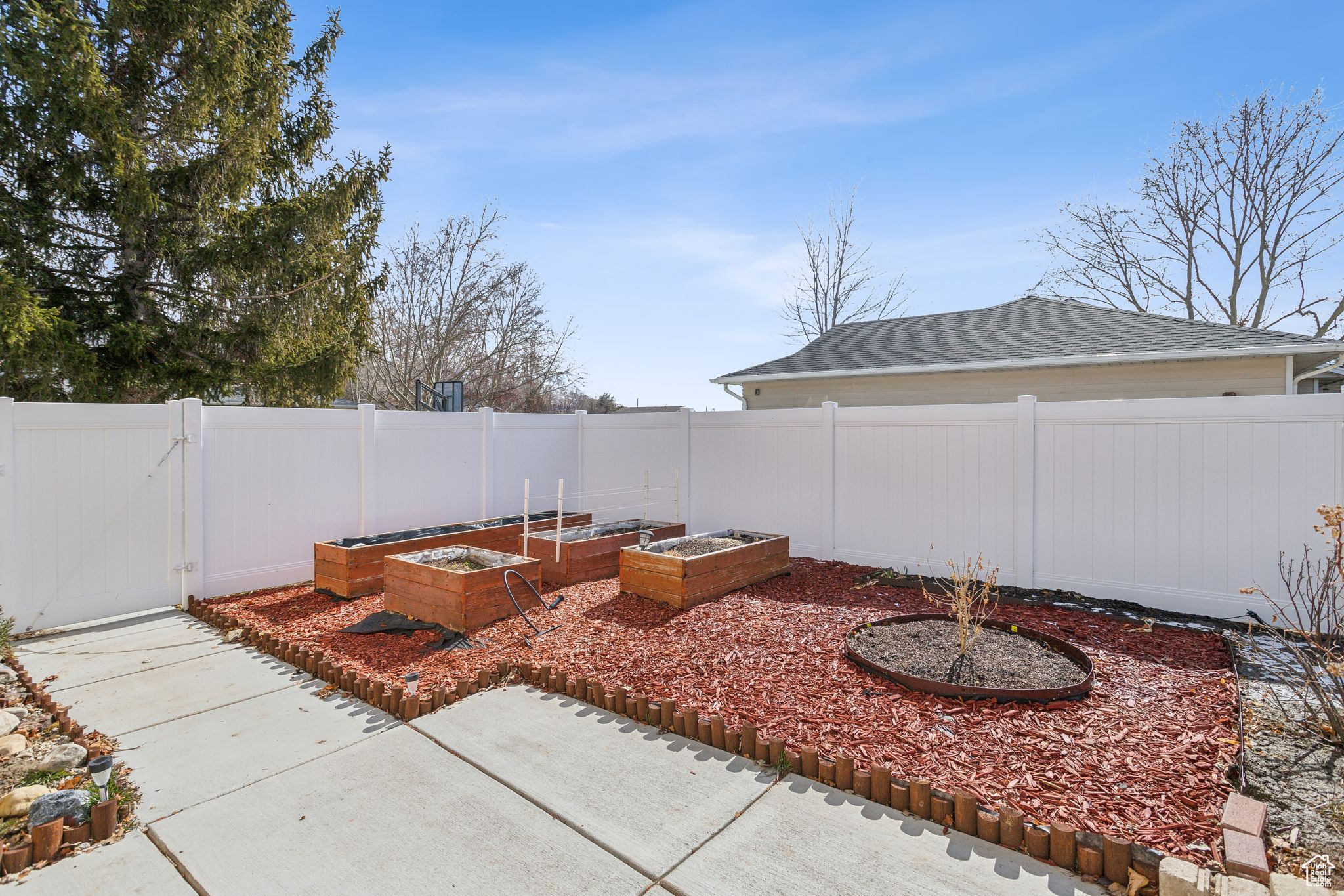 View of yard featuring a garden, a gate, and a fenced backyard