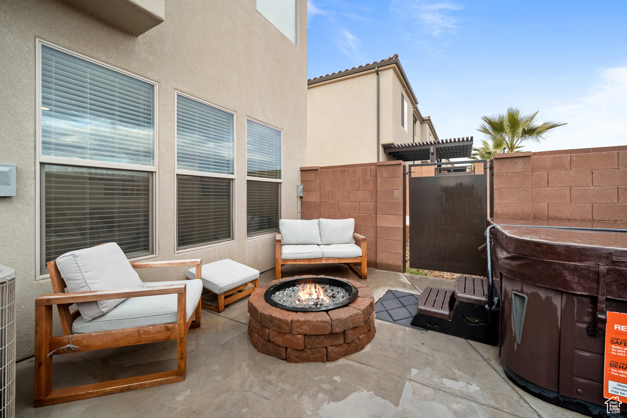 View of patio featuring an outdoor fire pit and fence