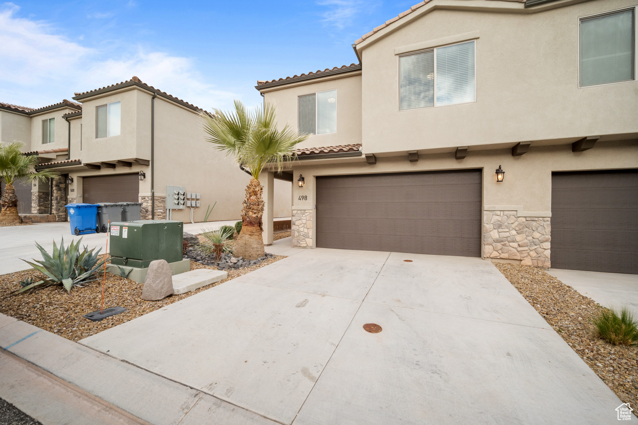 View of front of house featuring stone siding, an attached garage, concrete driveway, and stucco siding
