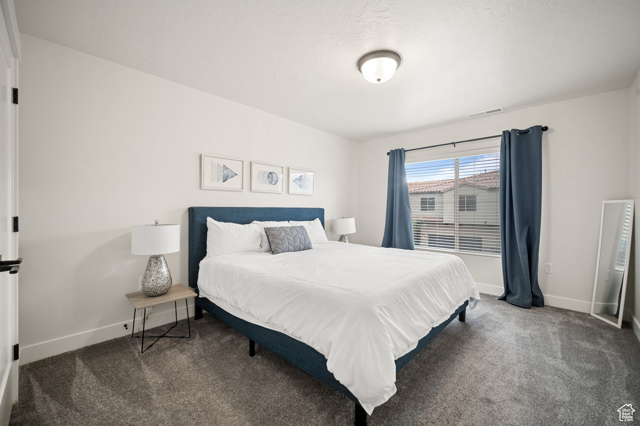 Carpeted bedroom with visible vents and baseboards
