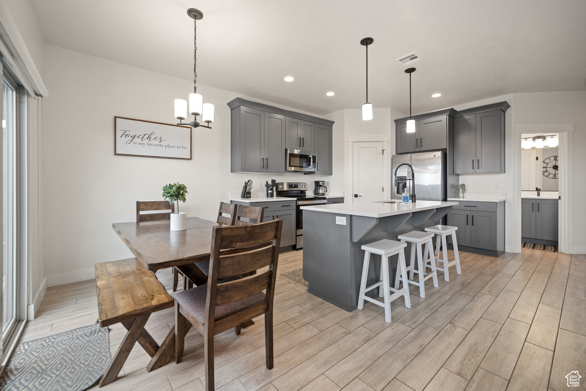 Kitchen with stainless steel appliances, gray cabinets, light countertops, visible vents, and wood tiled floor
