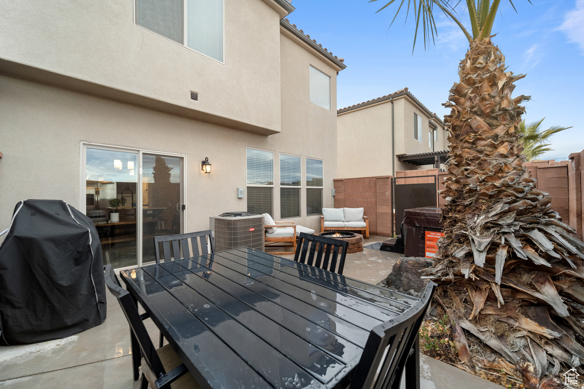 View of patio / terrace featuring a hot tub, area for grilling, a fenced backyard, outdoor dining area, and central AC