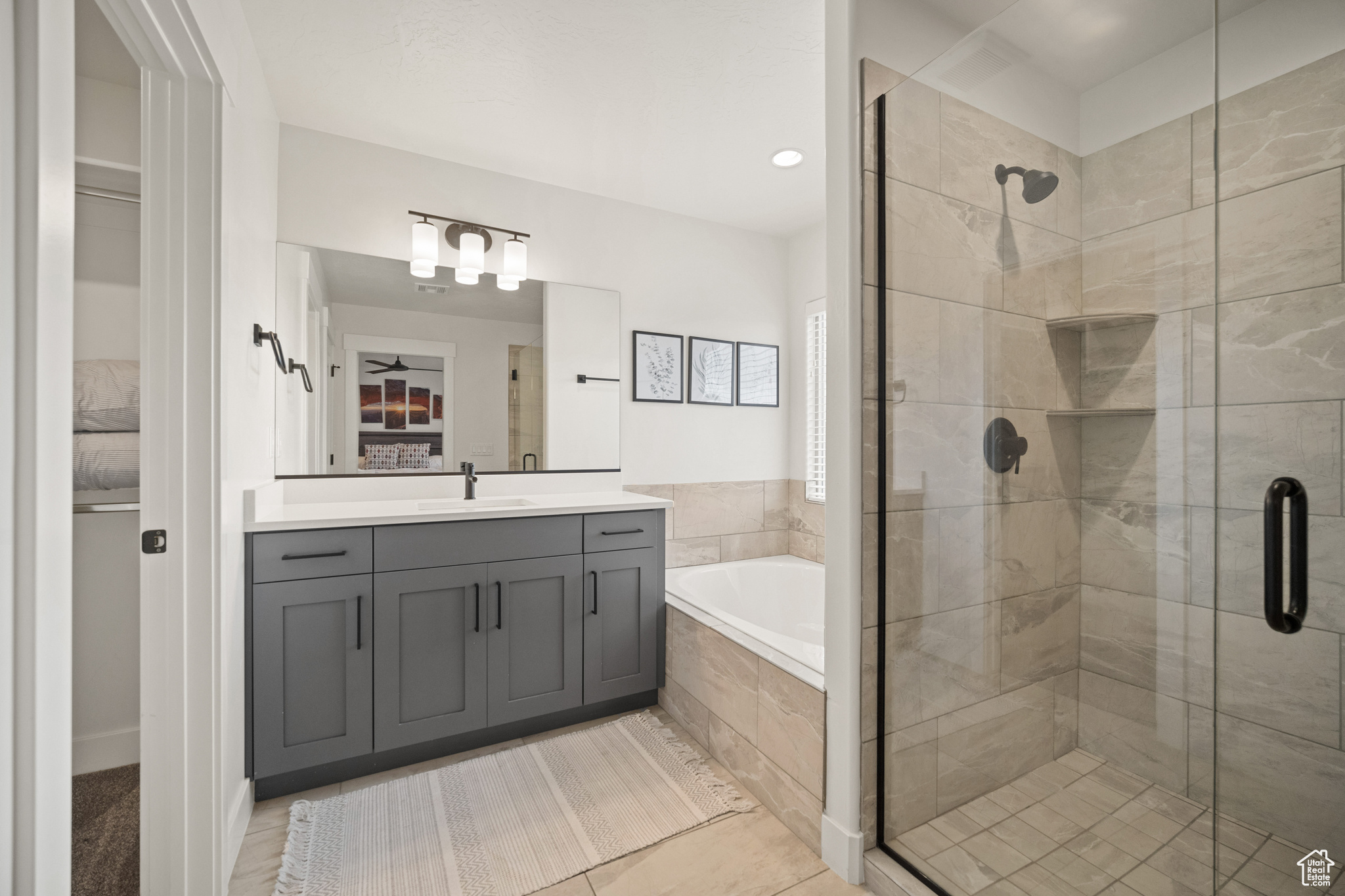 Bathroom featuring a stall shower, vanity, and a bath
