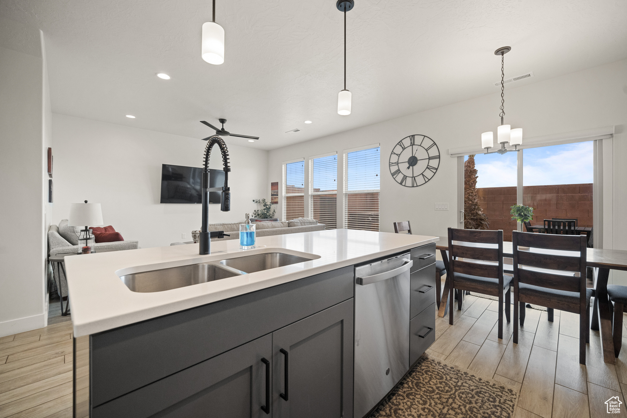 Kitchen with a sink, wood tiled floor, open floor plan, and dishwasher