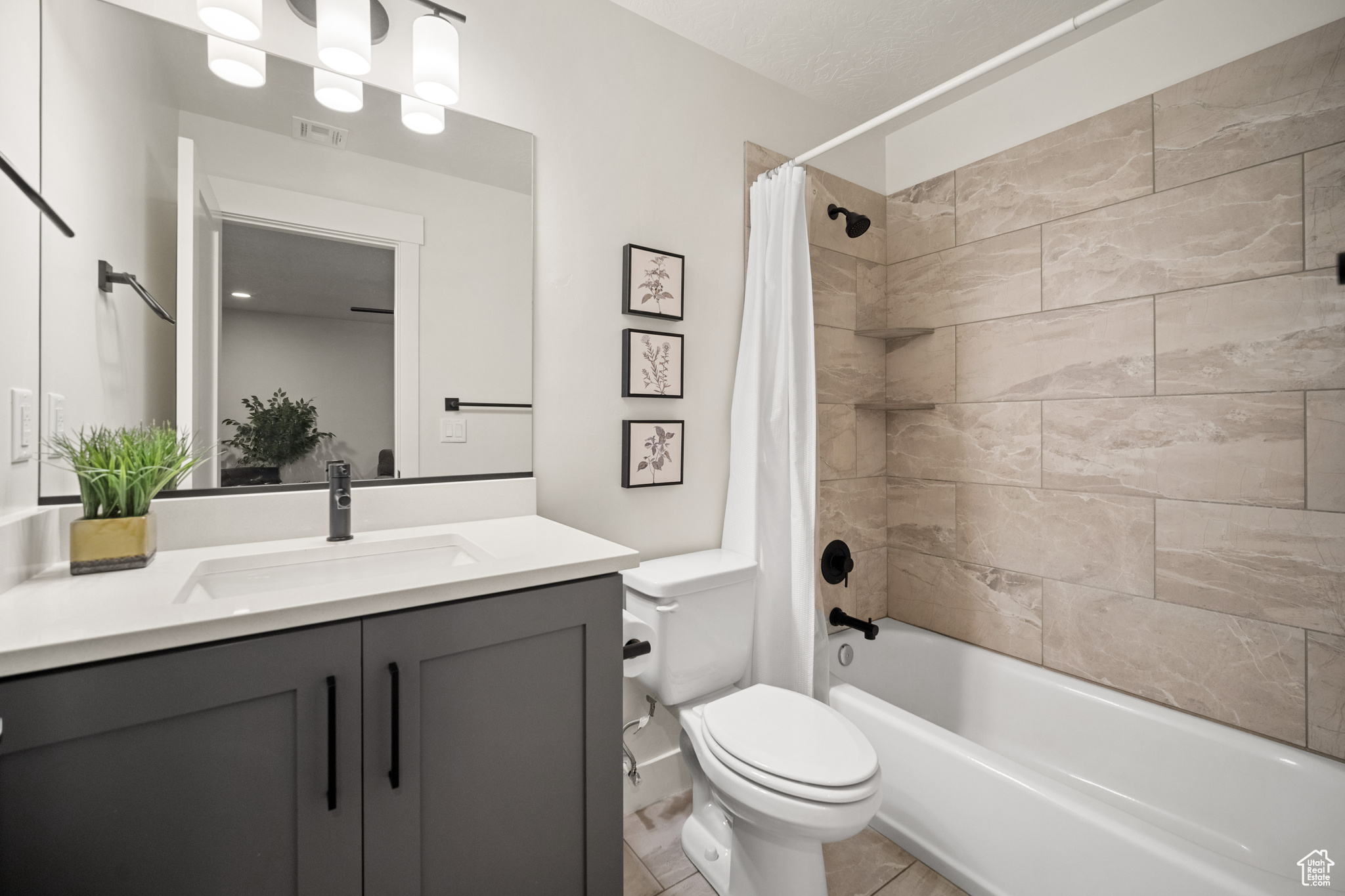 Bathroom with toilet, visible vents, shower / bath combo with shower curtain, and vanity