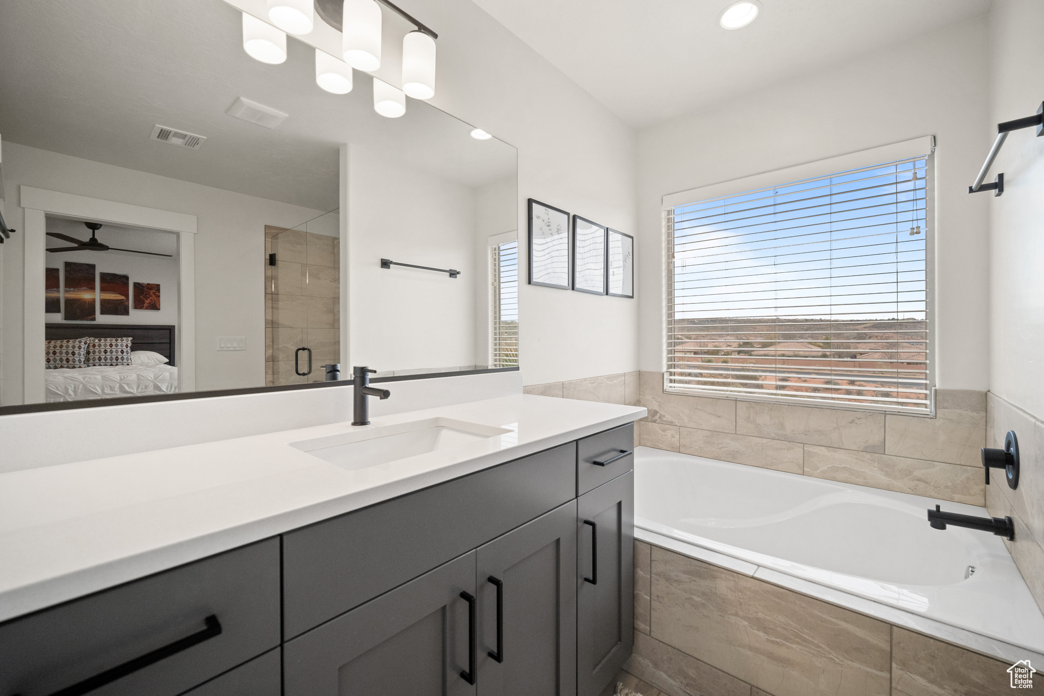 Ensuite bathroom with a garden tub, vanity, visible vents, a shower stall, and ensuite bath