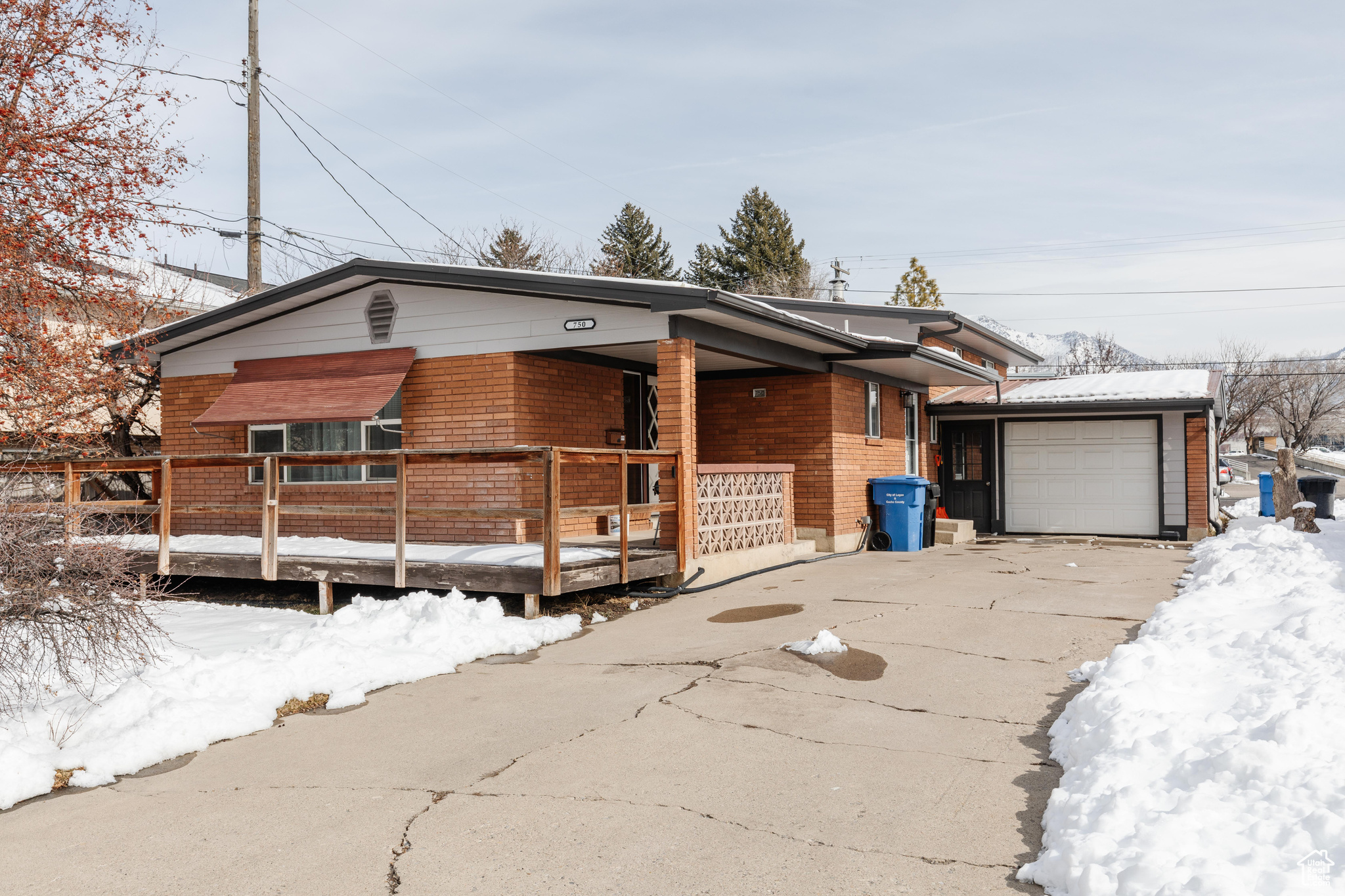 View of front of house with concrete driveway, brick siding, and an attached garage