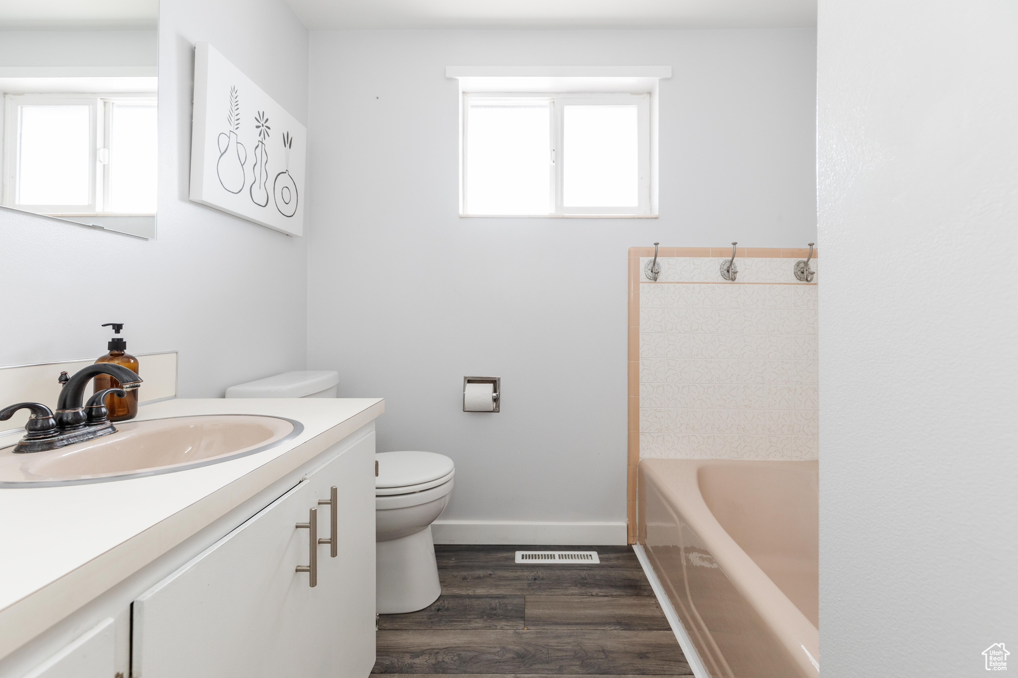 Full bathroom with a tub, wood finished floors, a wealth of natural light, and vanity