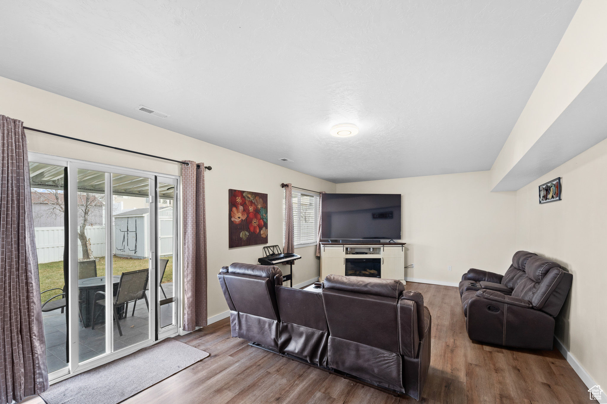 Living room featuring light wood-style floors, plenty of natural light, and visible vents