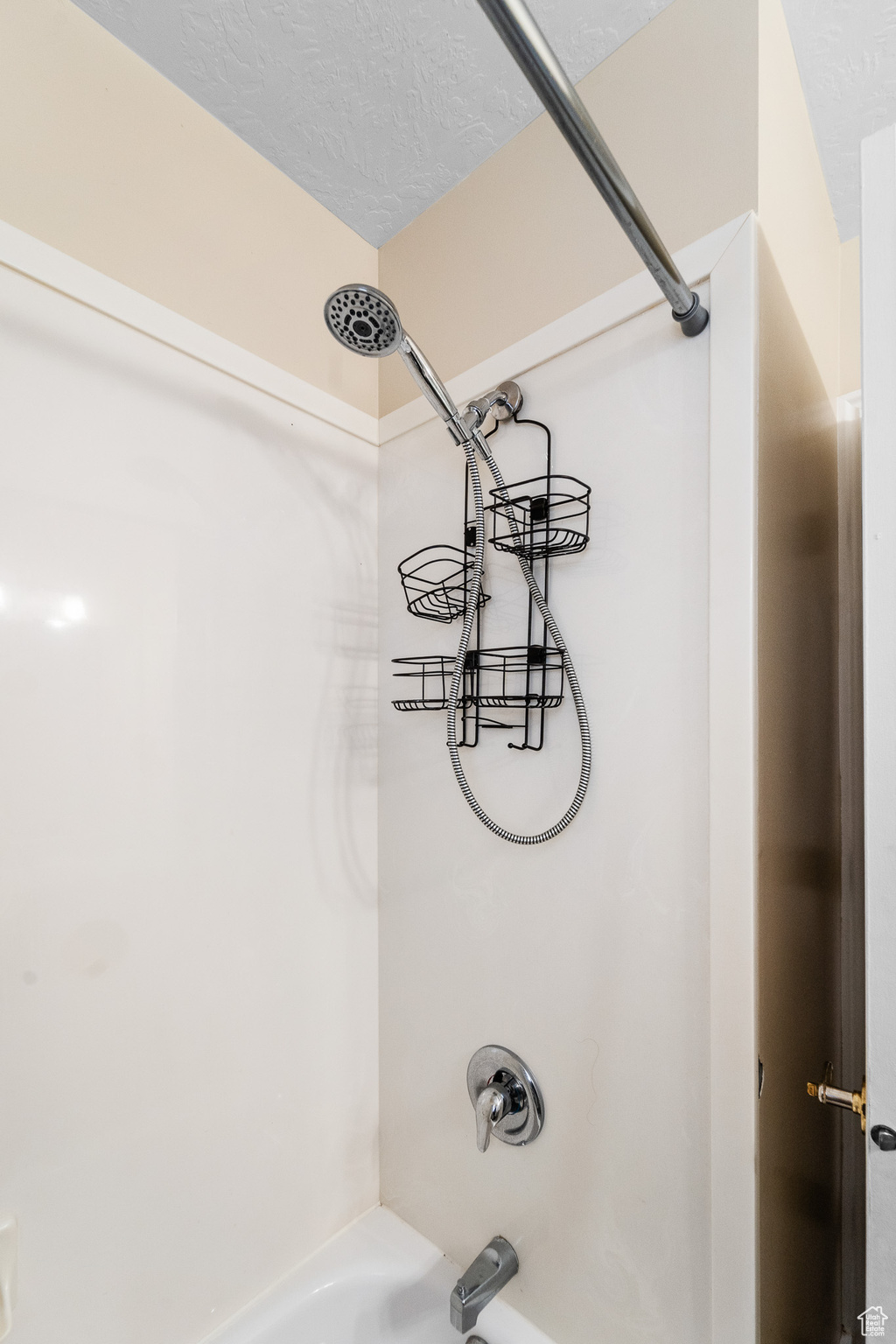 Details with shower / bathtub combination and a textured ceiling