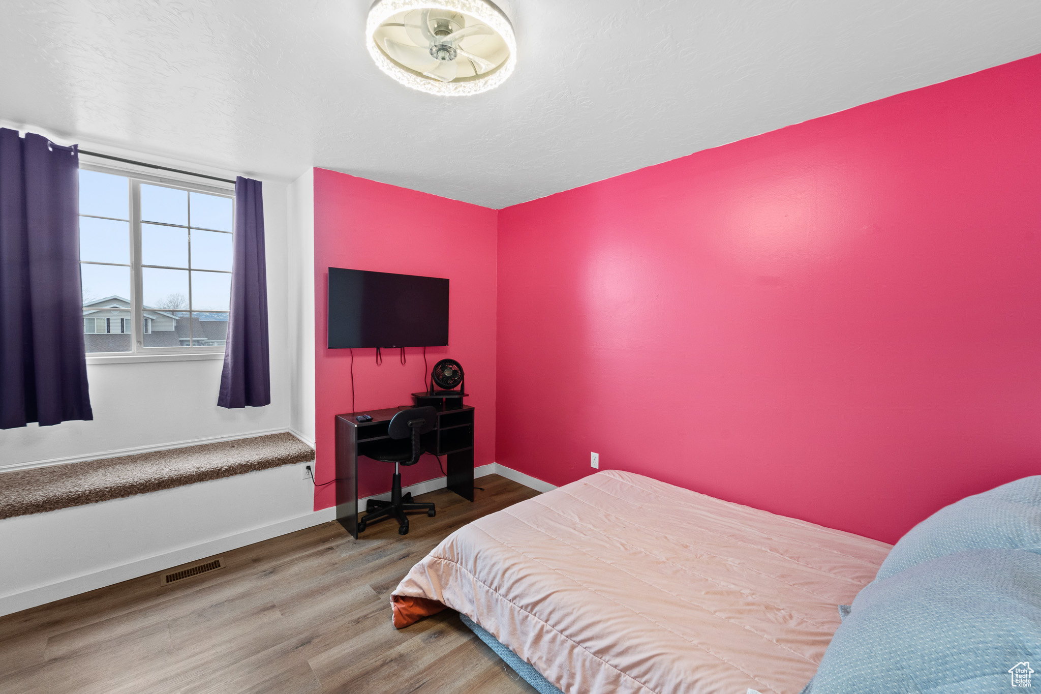 Bedroom with visible vents, a textured ceiling, baseboards, and wood finished floors