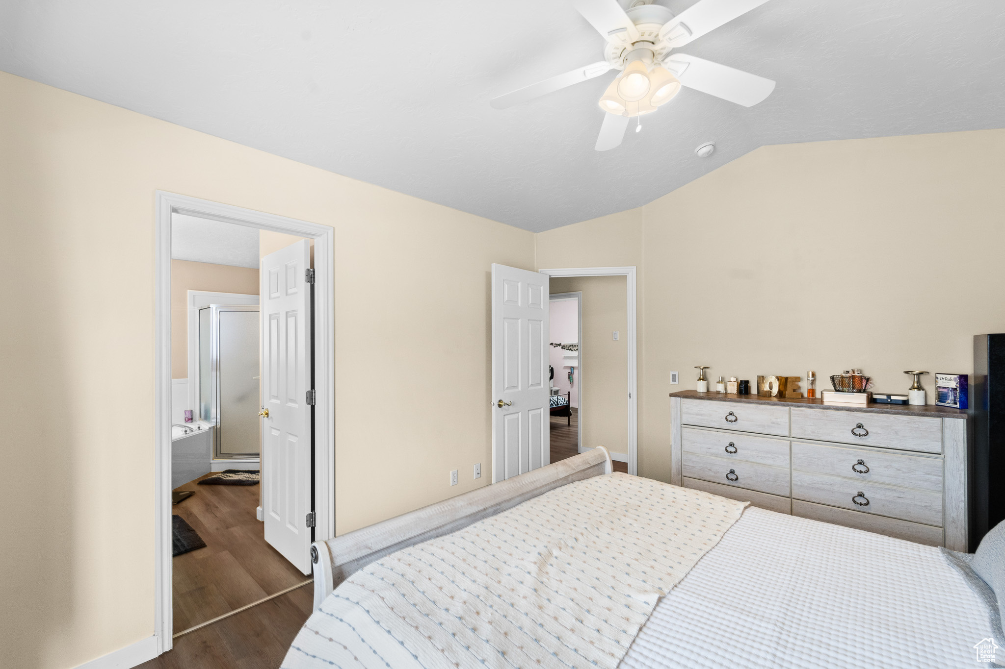 Bedroom with vaulted ceiling, ceiling fan, dark wood finished floors, and baseboards