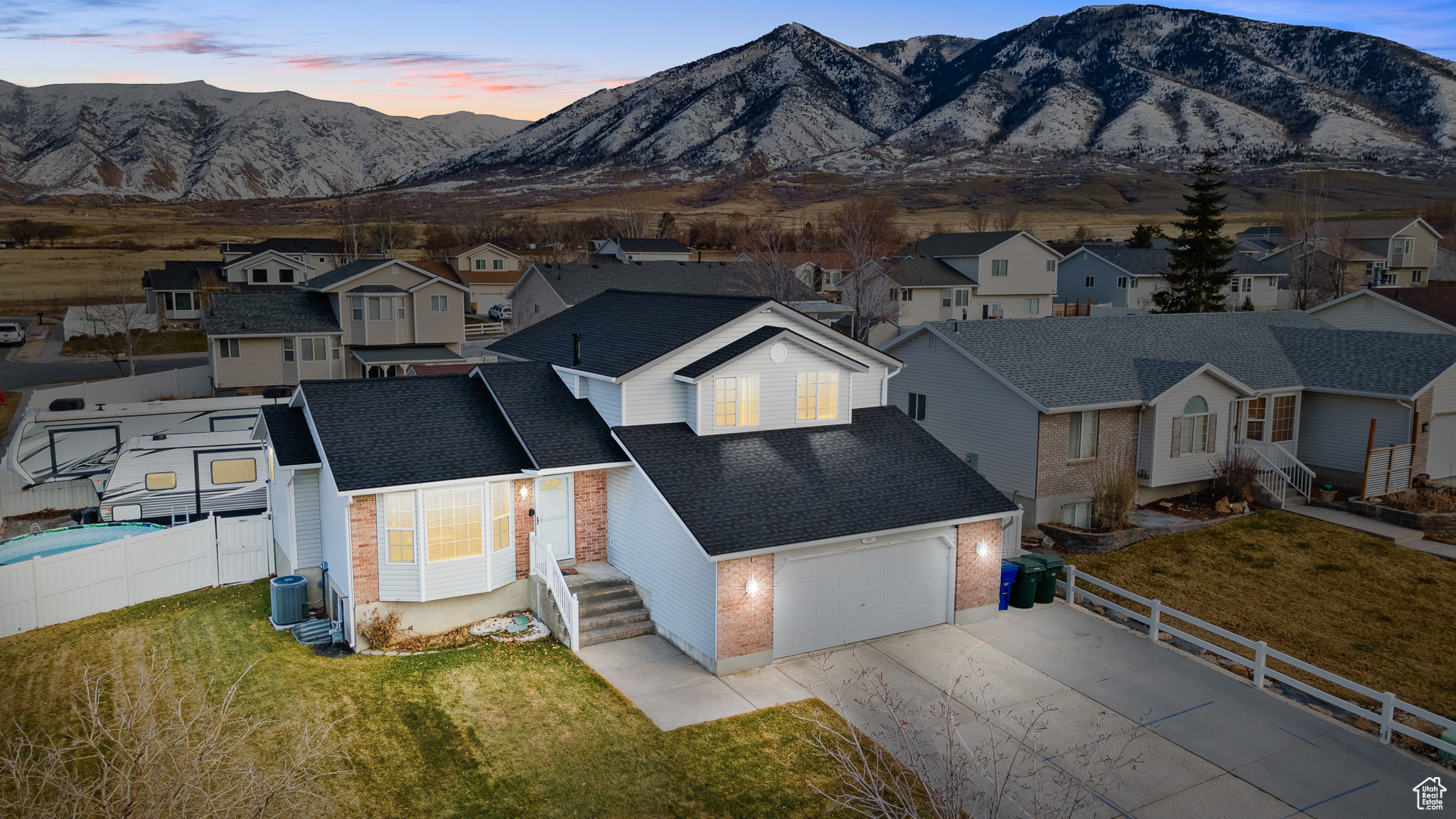 Traditional home featuring a yard, cooling unit, brick siding, and a mountain view