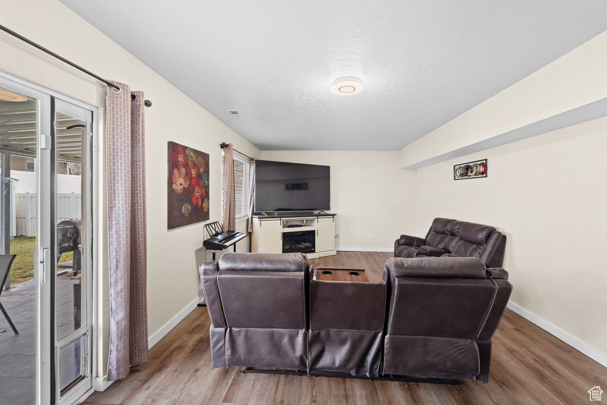 Living room with visible vents, a fireplace, light wood-style flooring, and baseboards