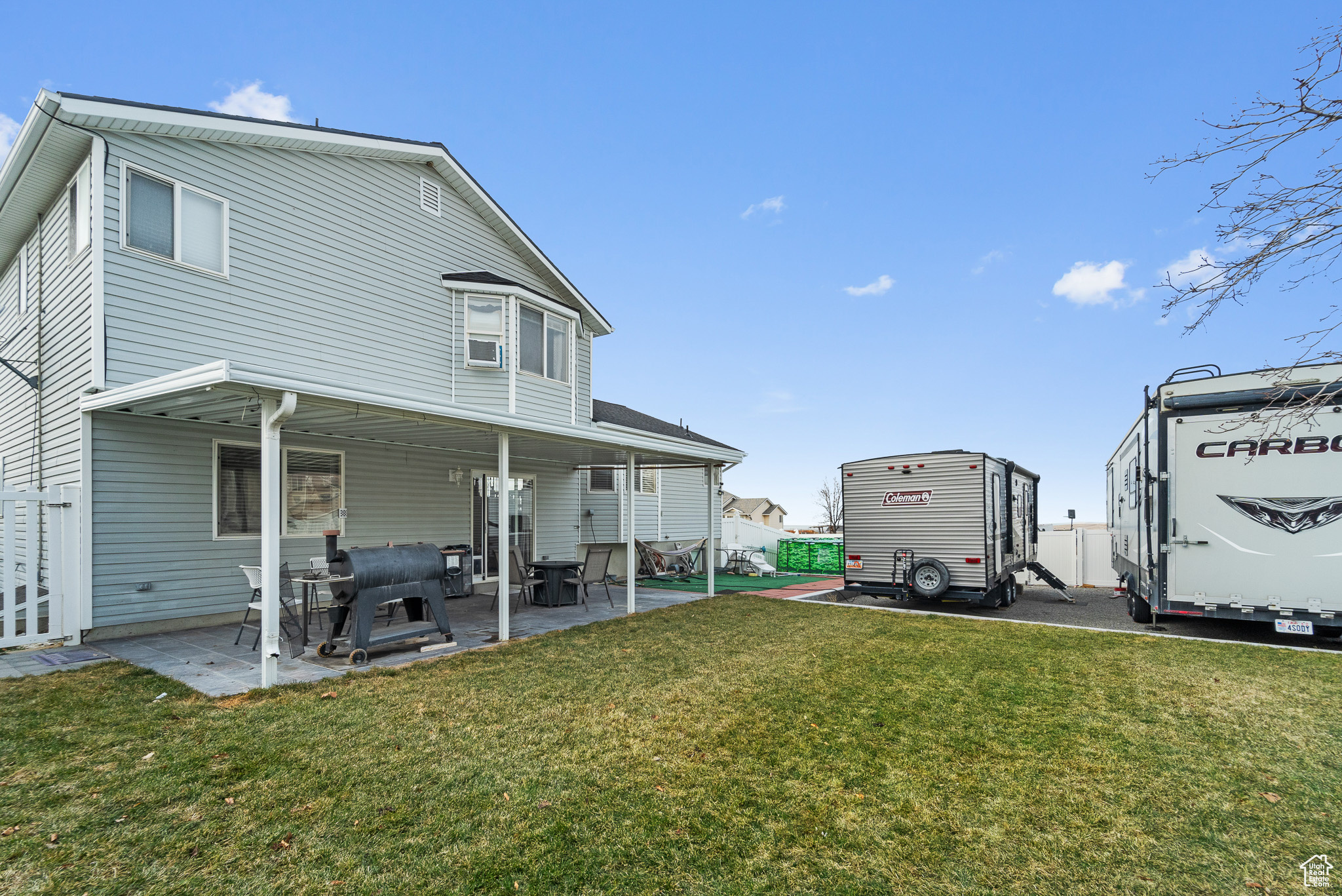 Back of property featuring a patio area, fence, and a yard