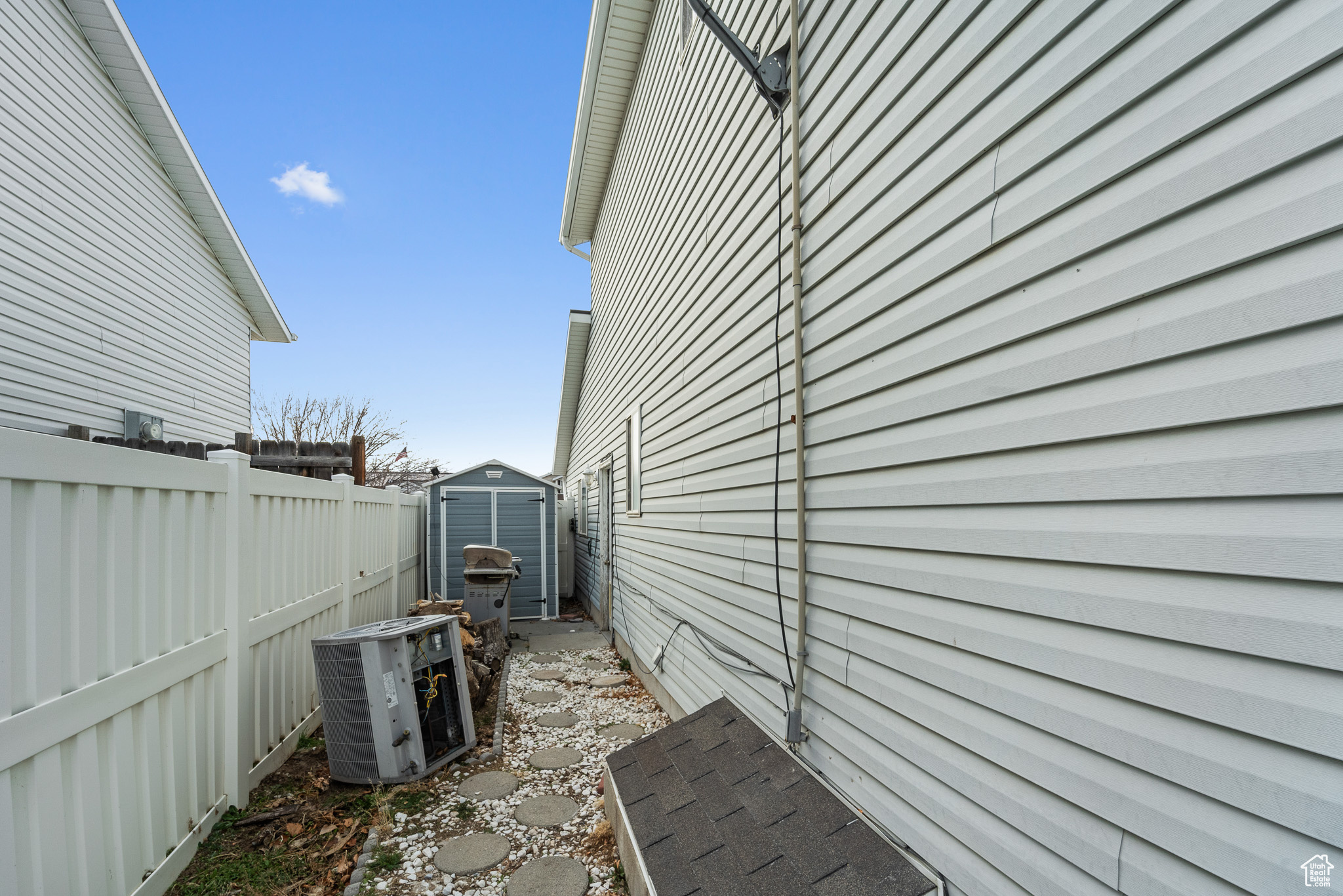 View of home's exterior featuring a storage unit, a fenced backyard, central AC unit, and an outdoor structure