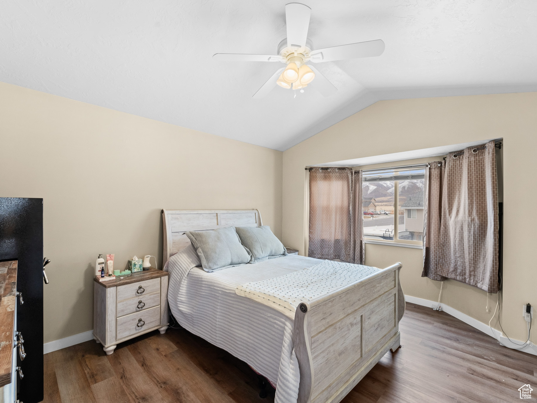 Bedroom featuring a ceiling fan, baseboards, vaulted ceiling, and dark wood finished floors