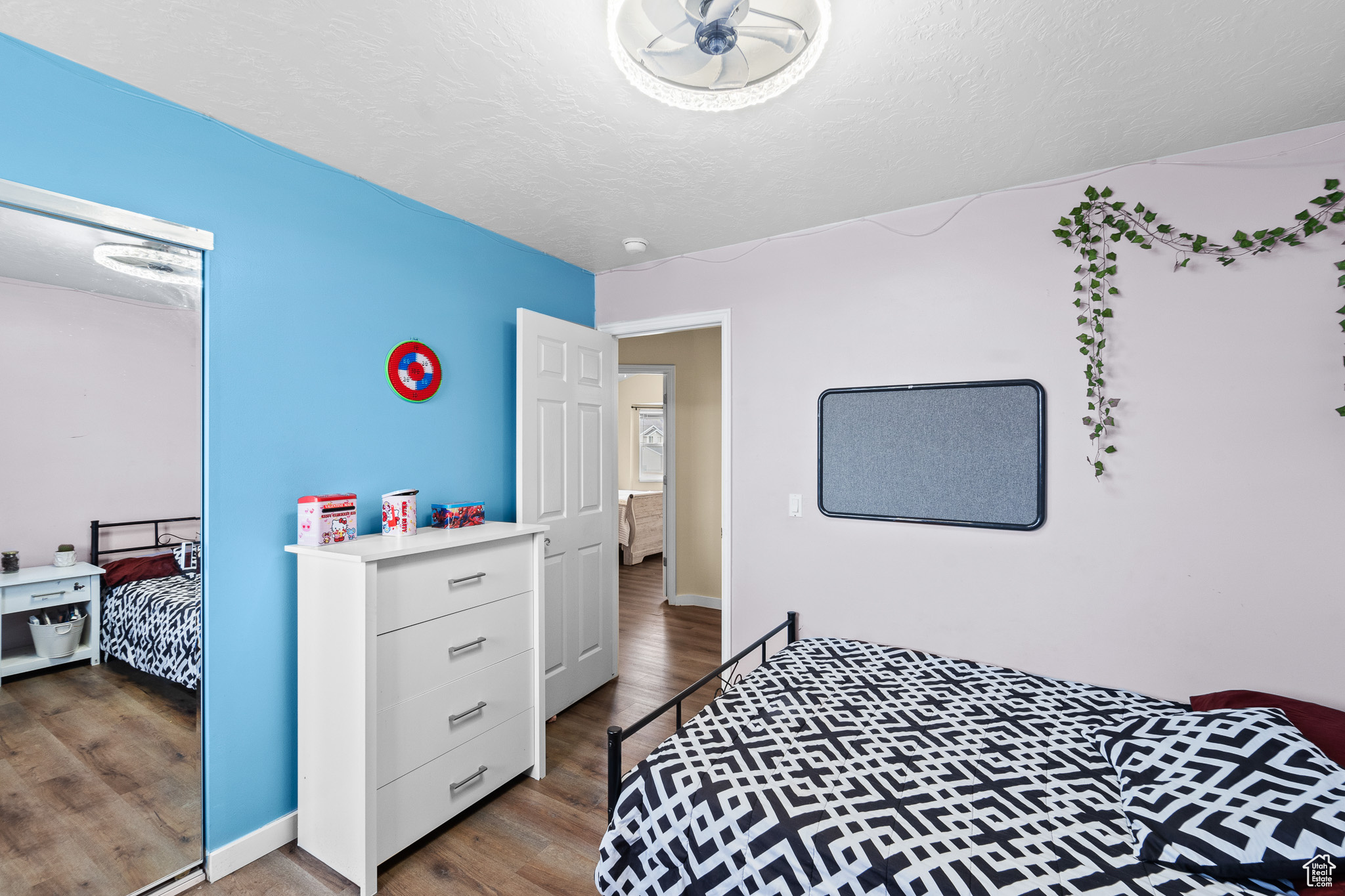 Bedroom featuring a textured ceiling, baseboards, and wood finished floors