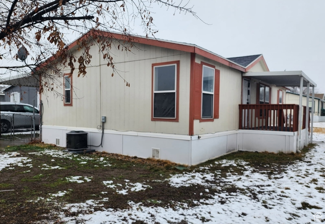 Snow covered property featuring crawl space and cooling unit