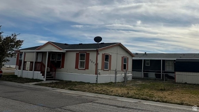 View of front of property with a sunroom and fence