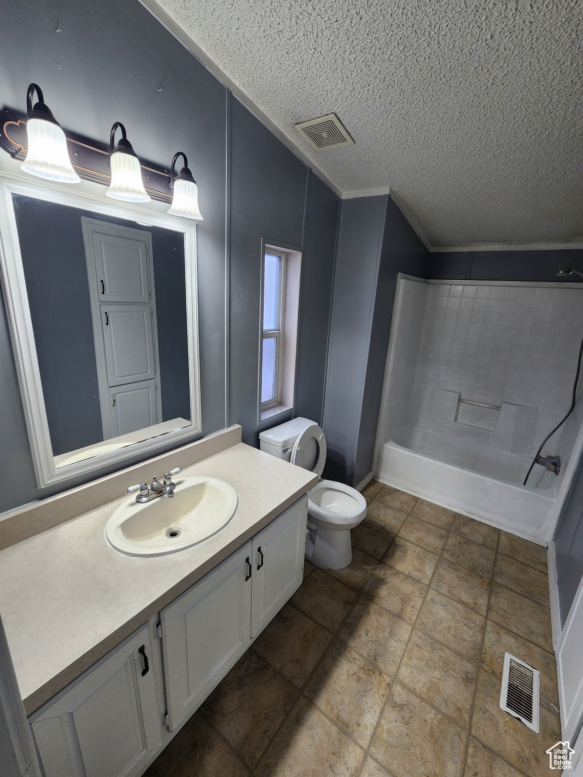 Bathroom with toilet, shower / bathing tub combination, vanity, and visible vents