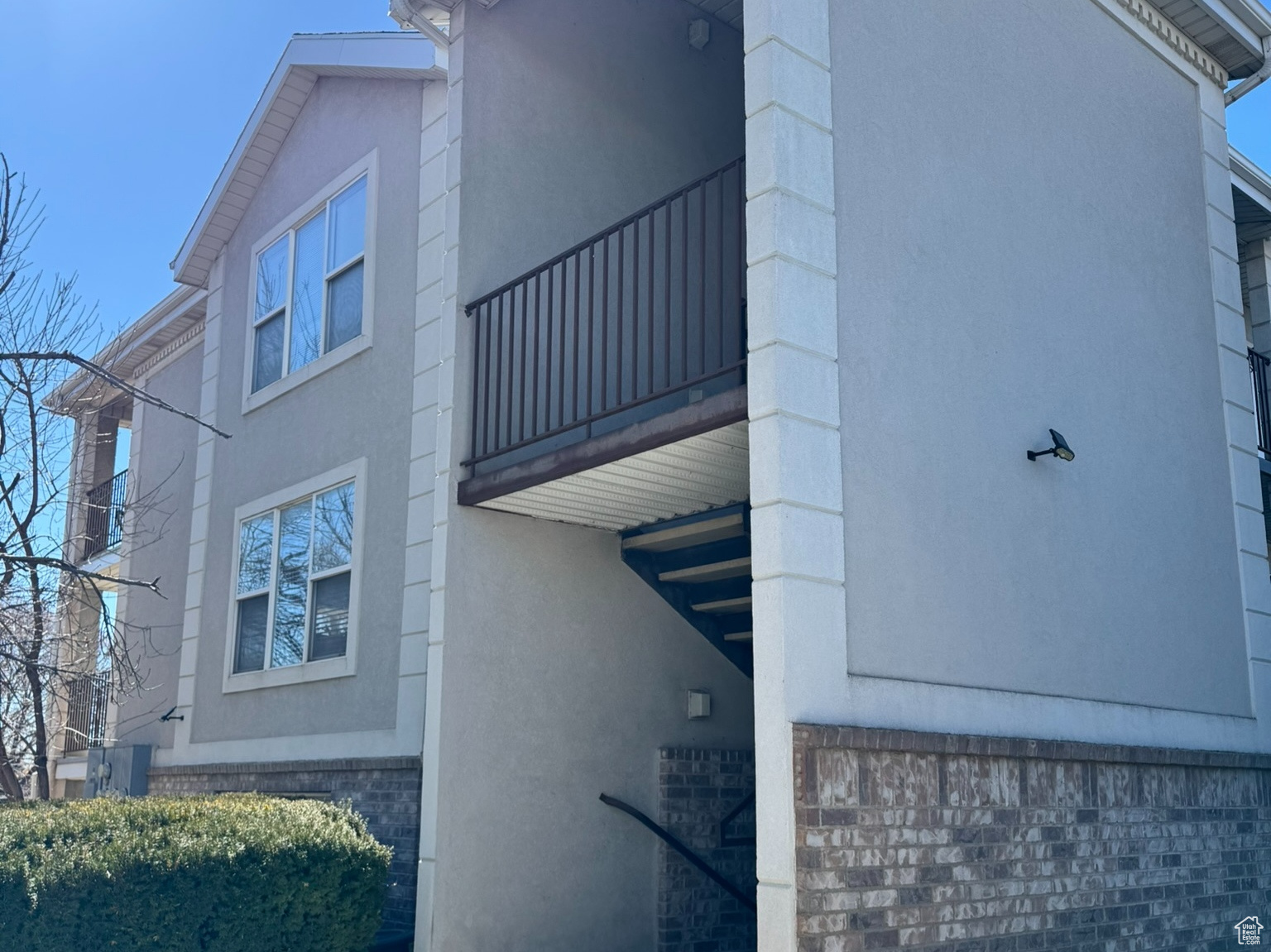 View of property exterior featuring a balcony and stucco siding
