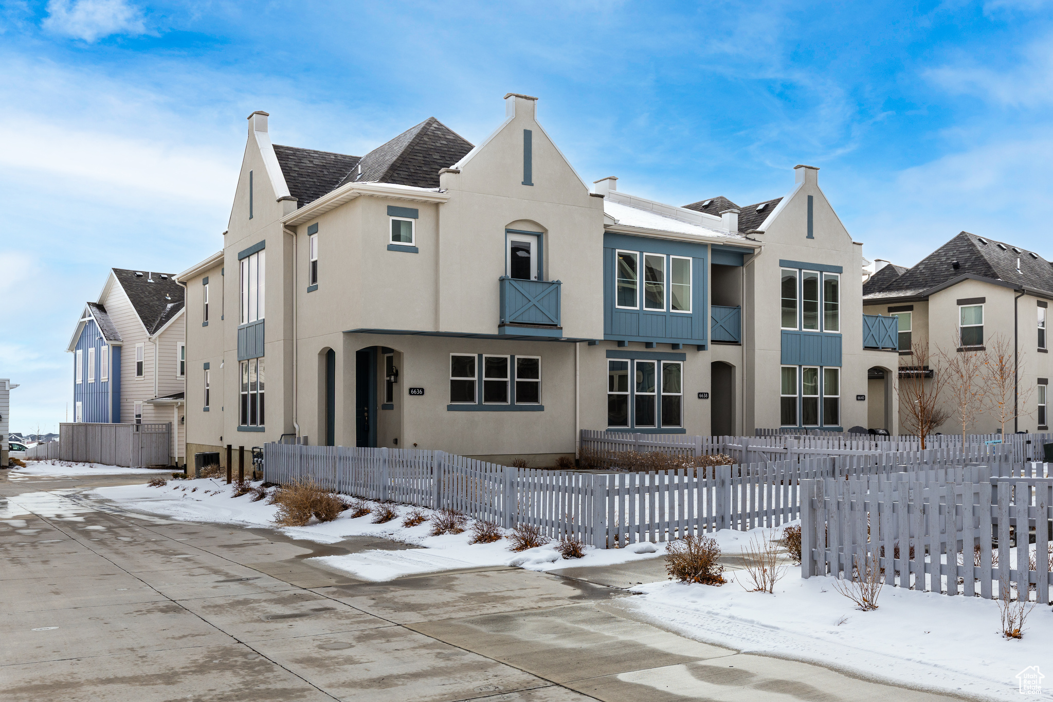 View of front facade with fence and stucco siding