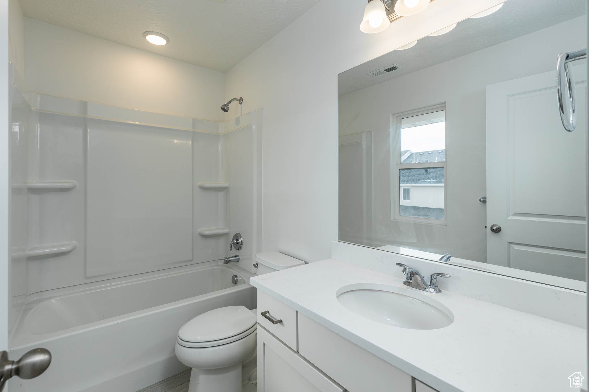 Bathroom featuring toilet, shower / bath combination, vanity, and visible vents
