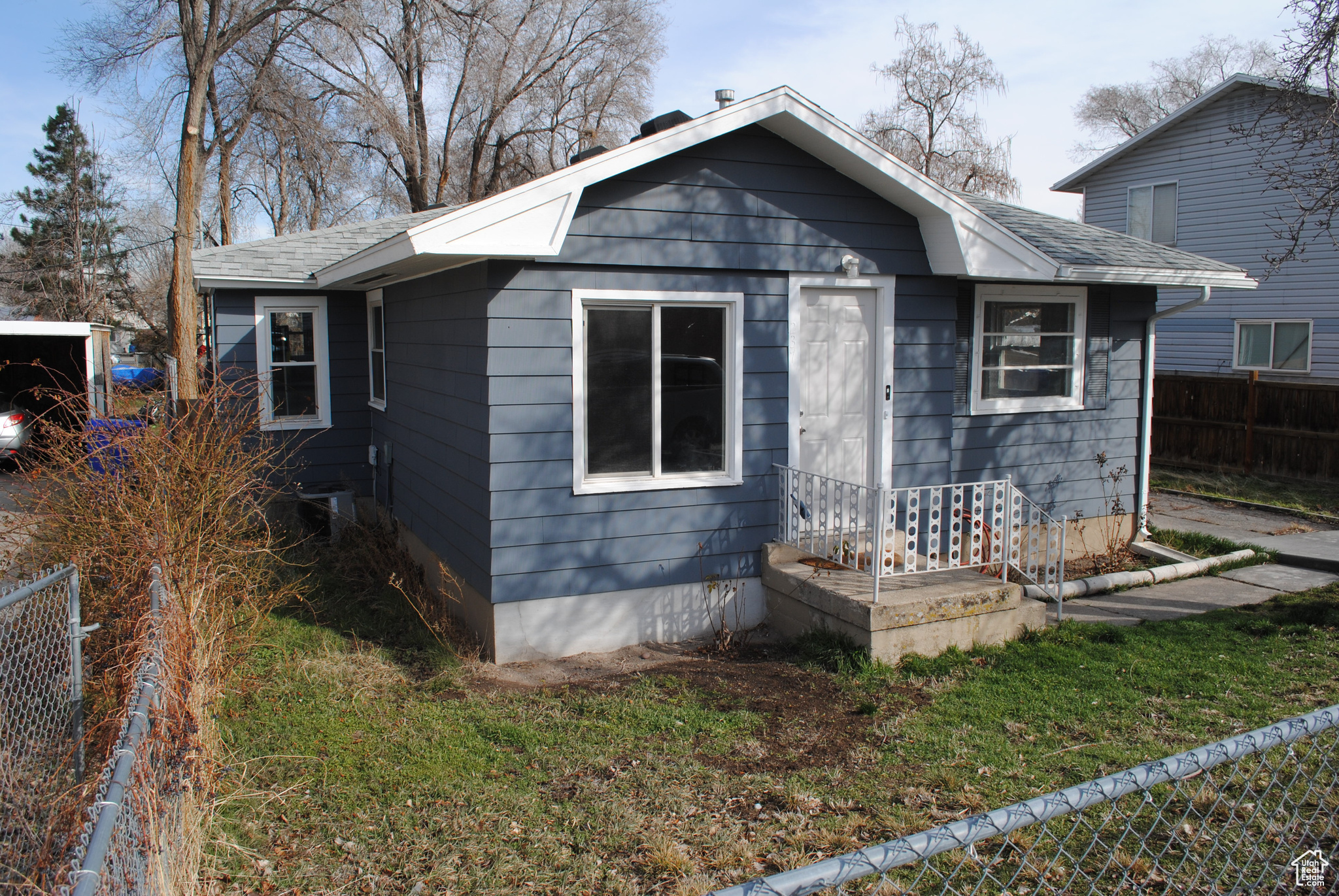 View of front of house with a shingled roof and fence